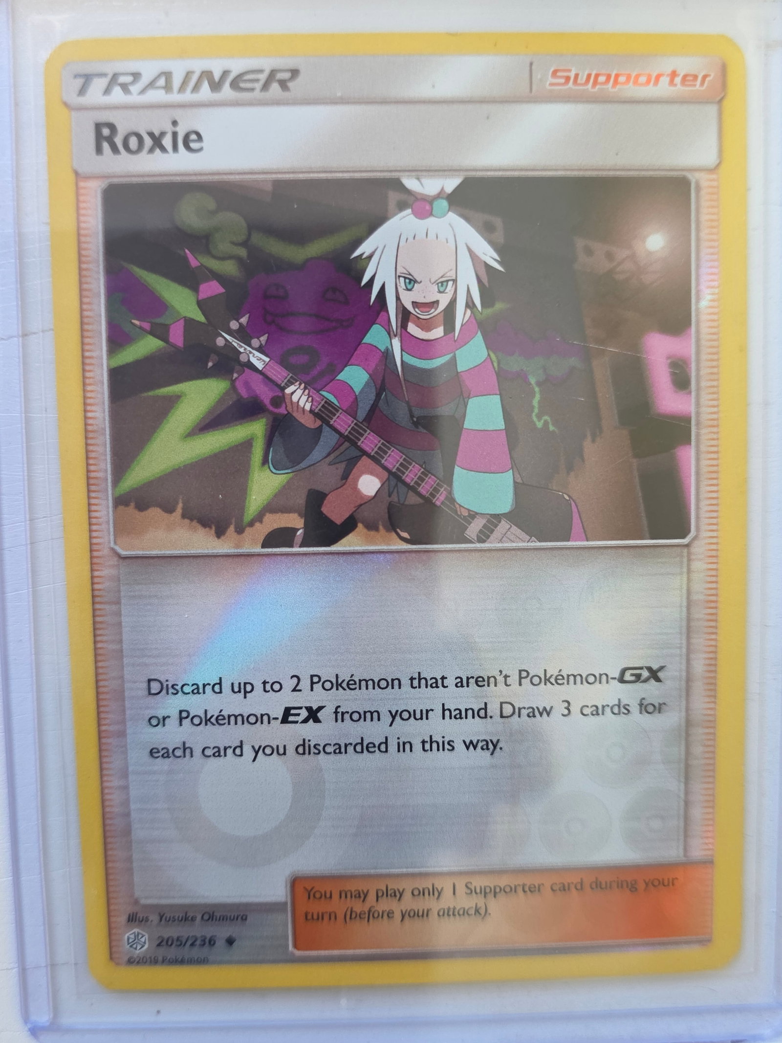 2019 Roxie Cosmic Eclipse 205/236 Pokemon Trainer Card: 2019 Pokemon Trainer Supporter card Roxie numbered 205/236 from the Sun & Moon Cosmic Eclipse expansion set. Illustrated by Yusuke Ohmura. Trainer supporter card stored in penny sleeve and top loader.