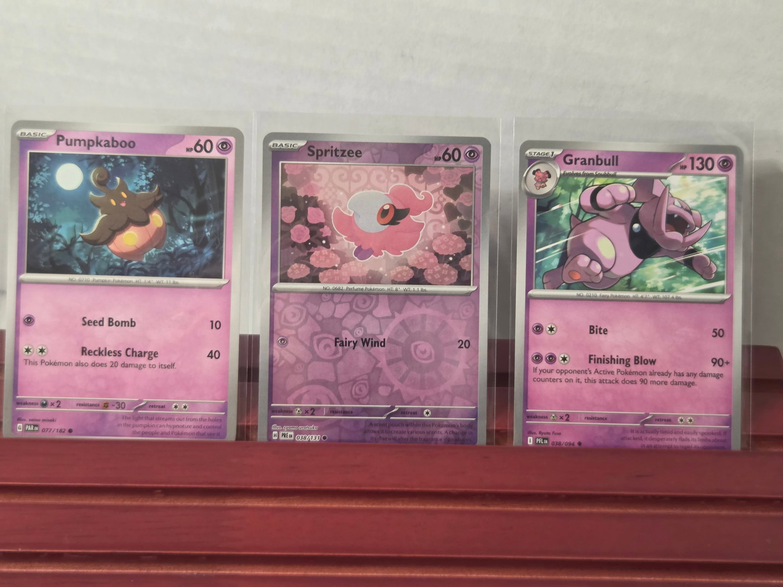 2023 Pumpkaboo Spritzee Granbull Pokemon Card Lot: Preowned lot of 3 Pokemon cards including Pumpkaboo 077/182, Spritzee 038/131, and Granbull 038/094. Mixed set lot featuring Psychic and Fairy type Pokemon. All standard non-holo cards. Stored in penn