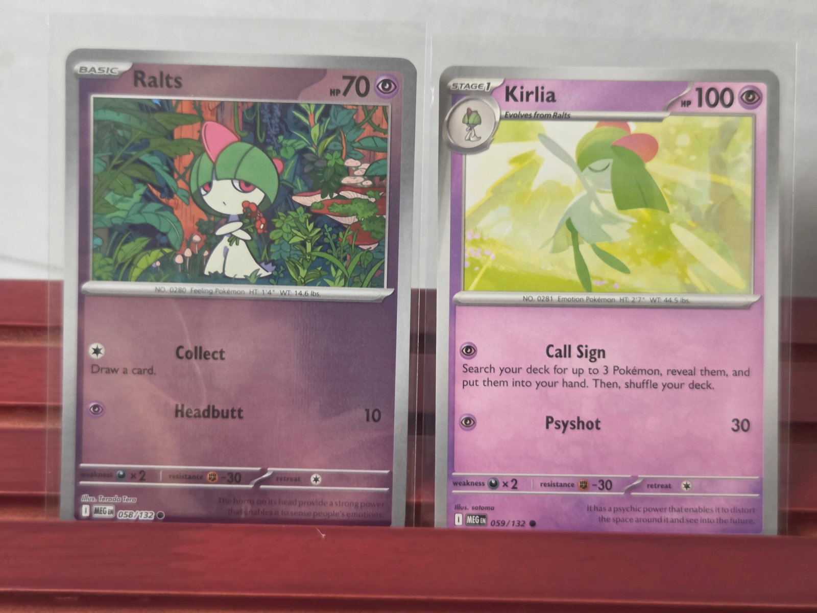2023 Ralts 058/132 Kirlia 059/132 Pokemon Card Lot: Preowned lot of 2 Pokemon cards including Ralts 058/132 and Kirlia 059/132 from the same set. Evolution pair featuring matching artwork style. Stored in penny sleeves and top loaders. Clean overall wi