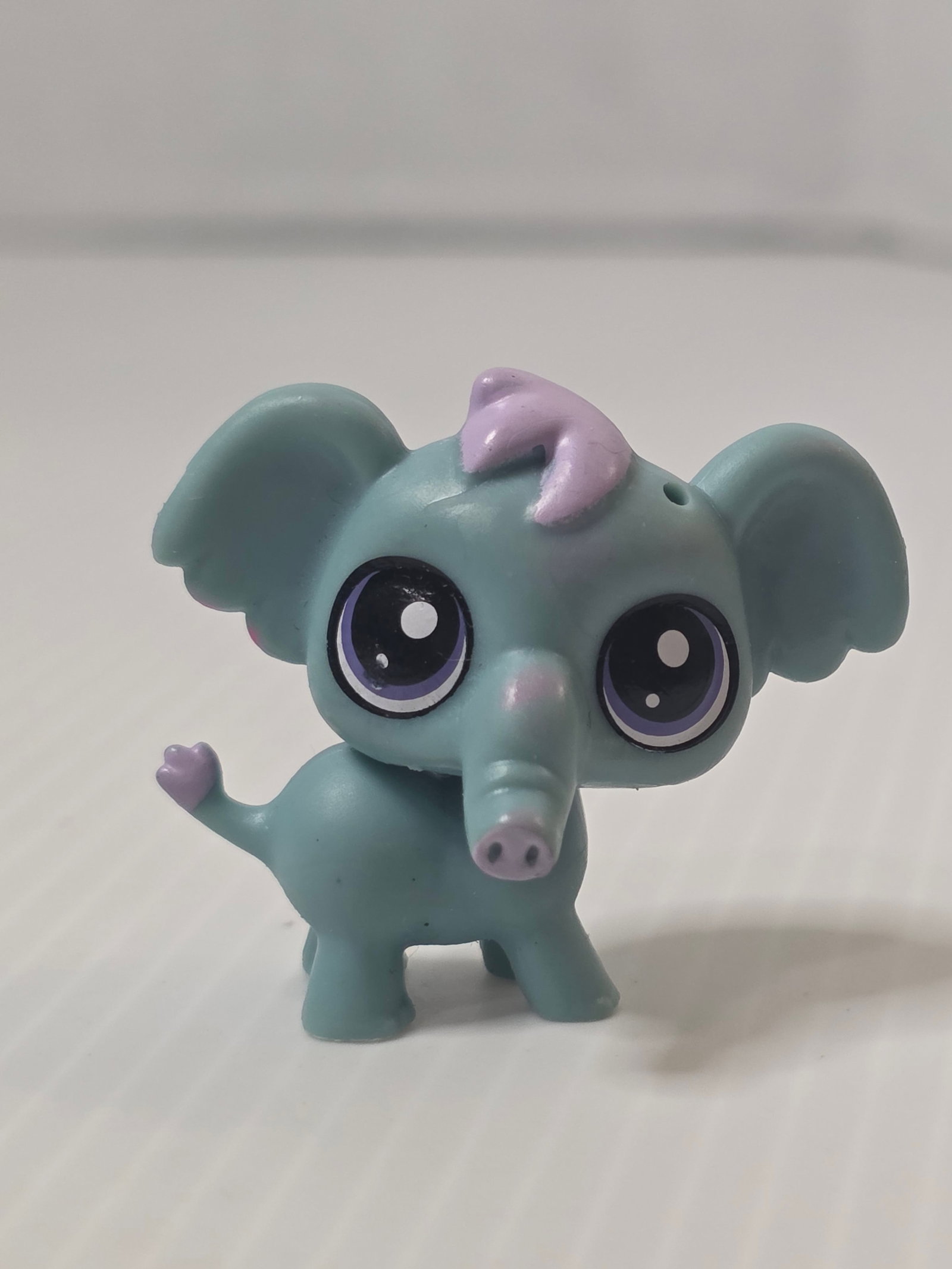 GEN 3 Gray Teal Elephant Purple Eyes LPS Hasbro: Littlest Pet Shop teal elephant figure from the Hasbro era. This Generation 3 style piece features a teal body with large ears, purple eyes, a lavender tuft on the head, and a small heart-tipped tail.