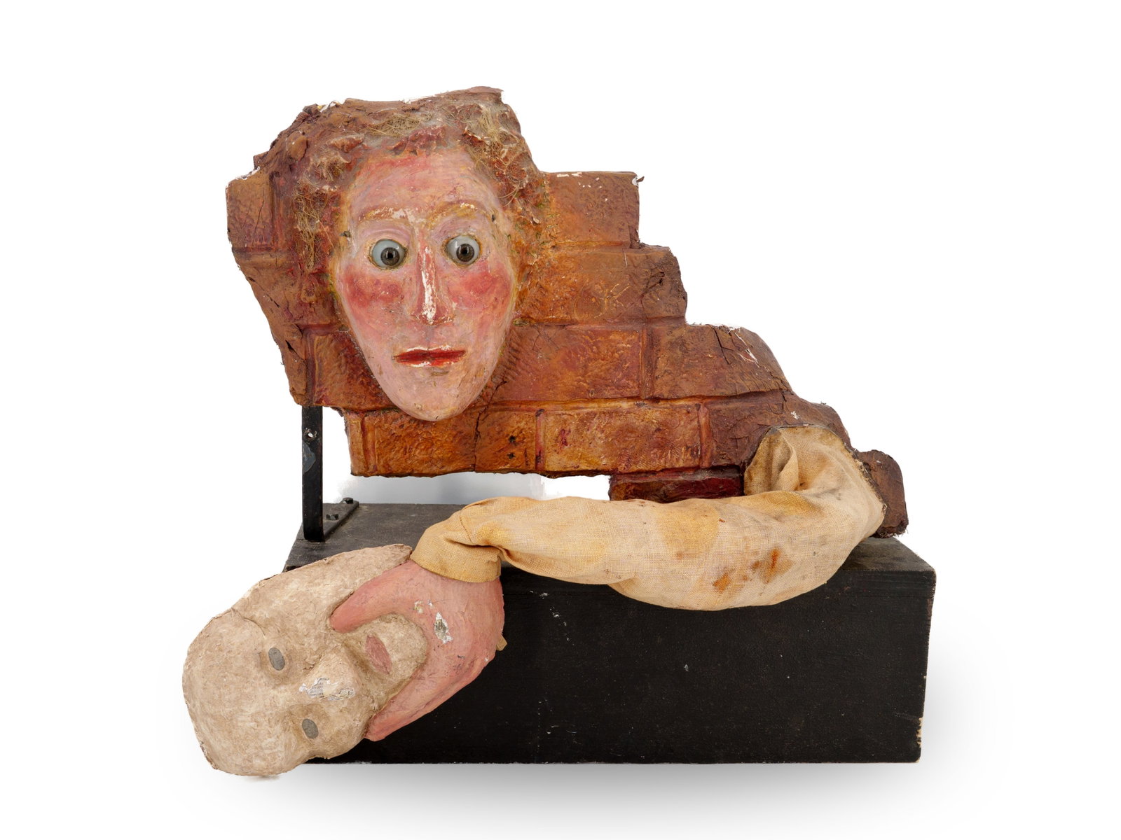 Unusual mannequin, face with mask, c. 1930: Unusual mannequin, face with mask, c. 1930Mannequin with a masked face, on a wooden base. The figure is made of plaster with inset glass eyes. The arm holding the mask presumably moves in front of the