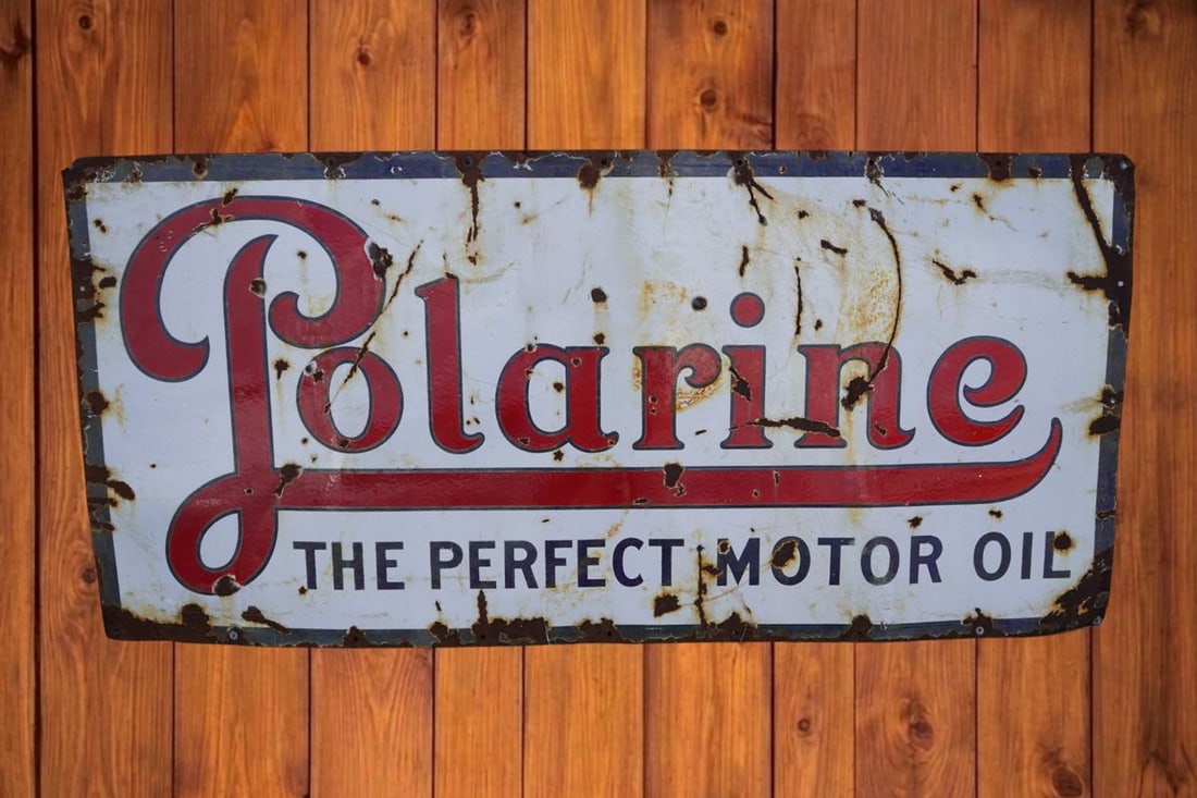 Original Polarine Single Sided Porcelain Sign: A rectangular white single sided porcelain advertising sign featuring red script text that reads 'Polarine' above 'THE PERFECT MOTOR OIL' in black block lettering. Shows heavy rust, patina, and edge w