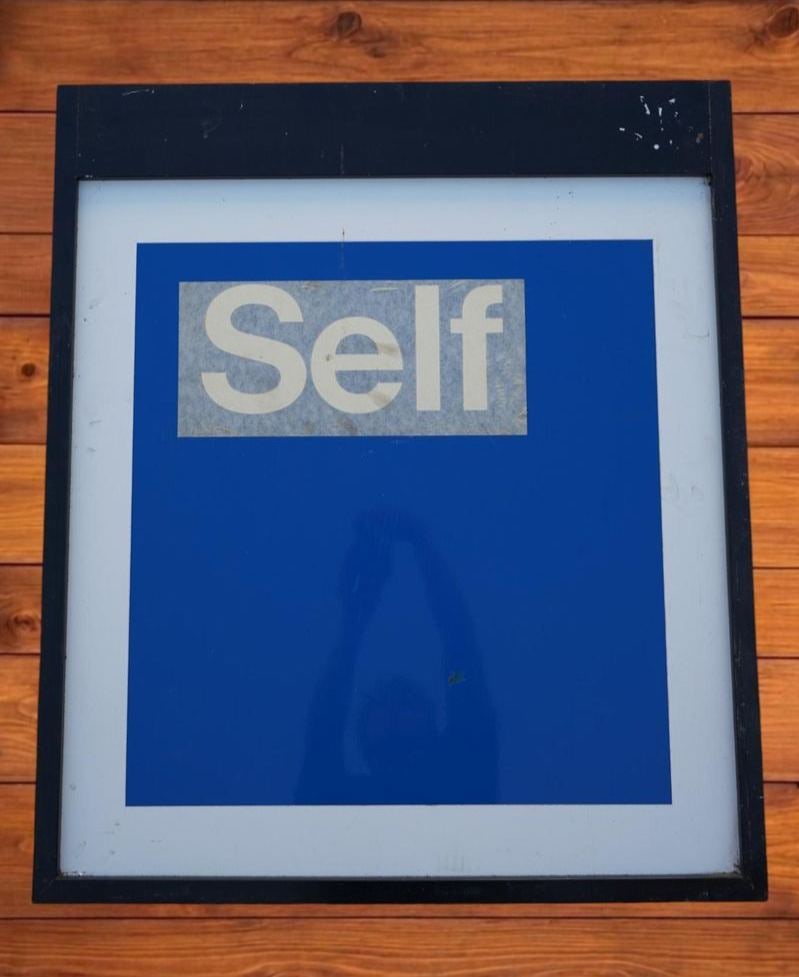 Vintage Mobil 'Self' Metal Sign Panel: A rectangular metal gas station utility sign with a split layout, featuring bold black block lettering that reads 'SELF'. It seems it was never used due to the paper still being over the words. It is