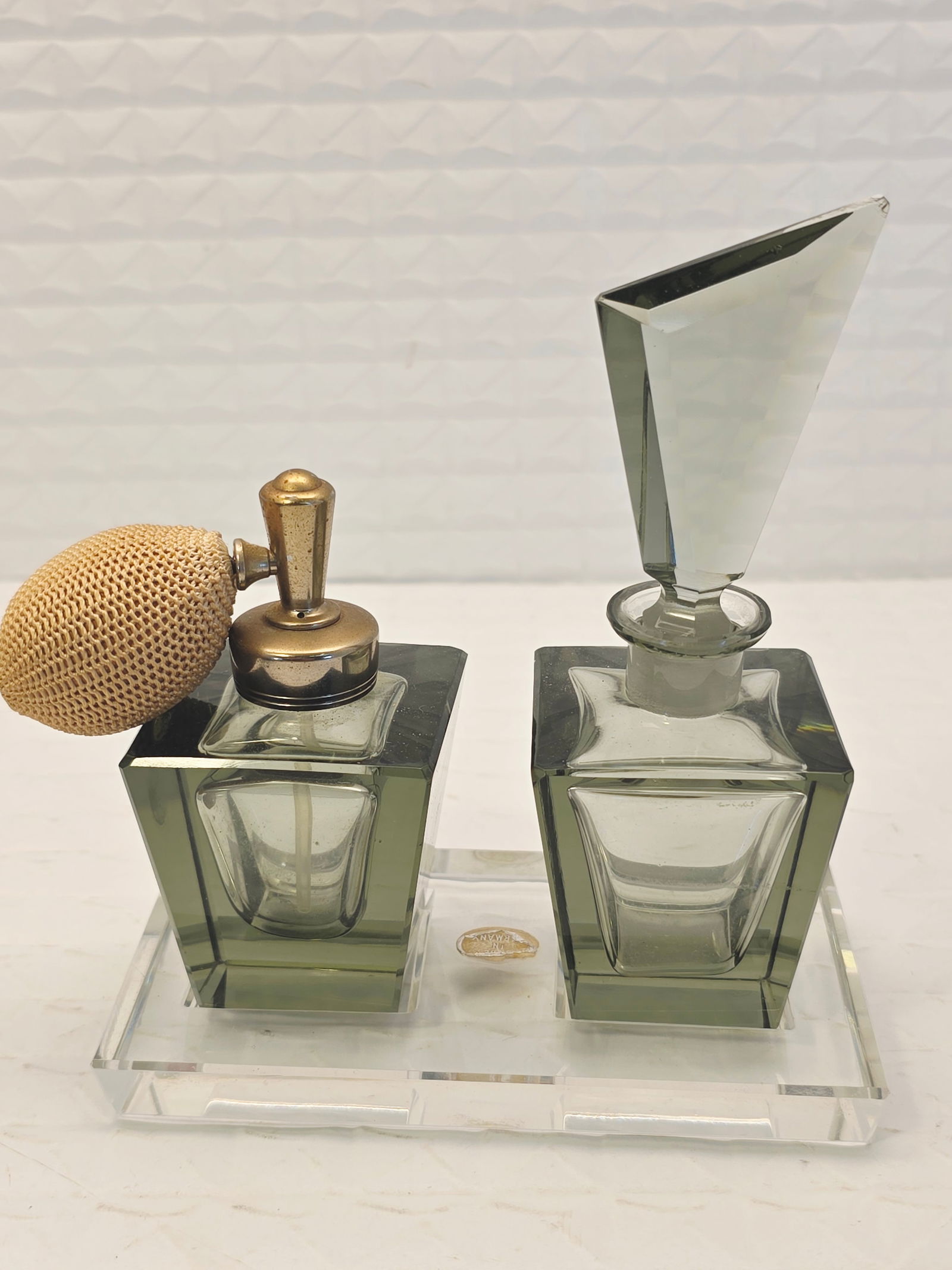 Art Deco glass perfume bottle set: vintage Art Deco glass perfume bottle set featuring a geometric design, possibly originating from the 1920s to 1950s. Design: colored glass bottle with a faceted or skyscraper-shaped stopper, and a ma