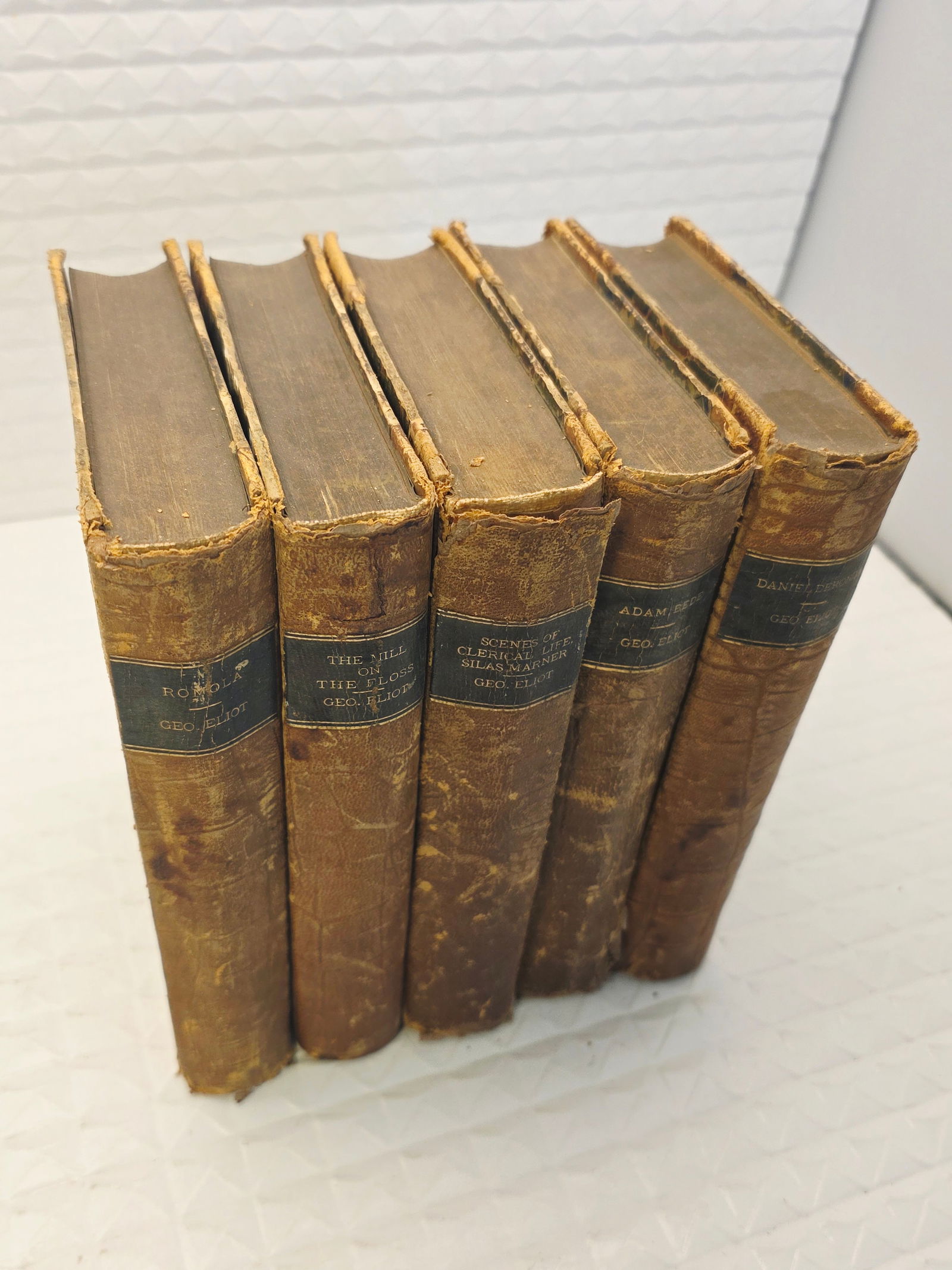 5 rare antique books by George Eliot: 5 antique booksantique, books,haredcover, leather, worn spines and aged appearance. A set of novels by the author George Eliot (pen name for Mary Ann Evans), specifically including Adam Bede and Scene