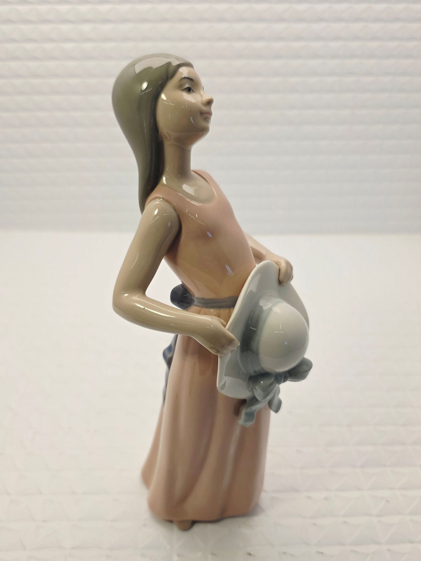 Retired Lladró porcelain sculpture Dreamer: Lladró porcelain sculpture officially titled "Dreamer" (Spanish name: Pamela Plantada), which depicts a young girl in a pink dress holding a sun hat. Product DetailsModel Number: #5008.Collection: Pa