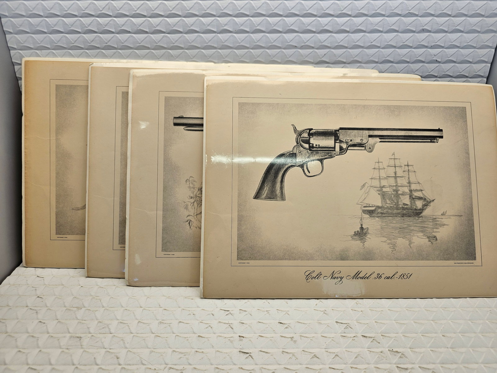 4 vintage Colt art prints: vintage 1950s Colt percussion revolver art prints, originally published by the San Francisco Gun Exchange.Content: The set features black and white etchings or sketches of various historical firearms,