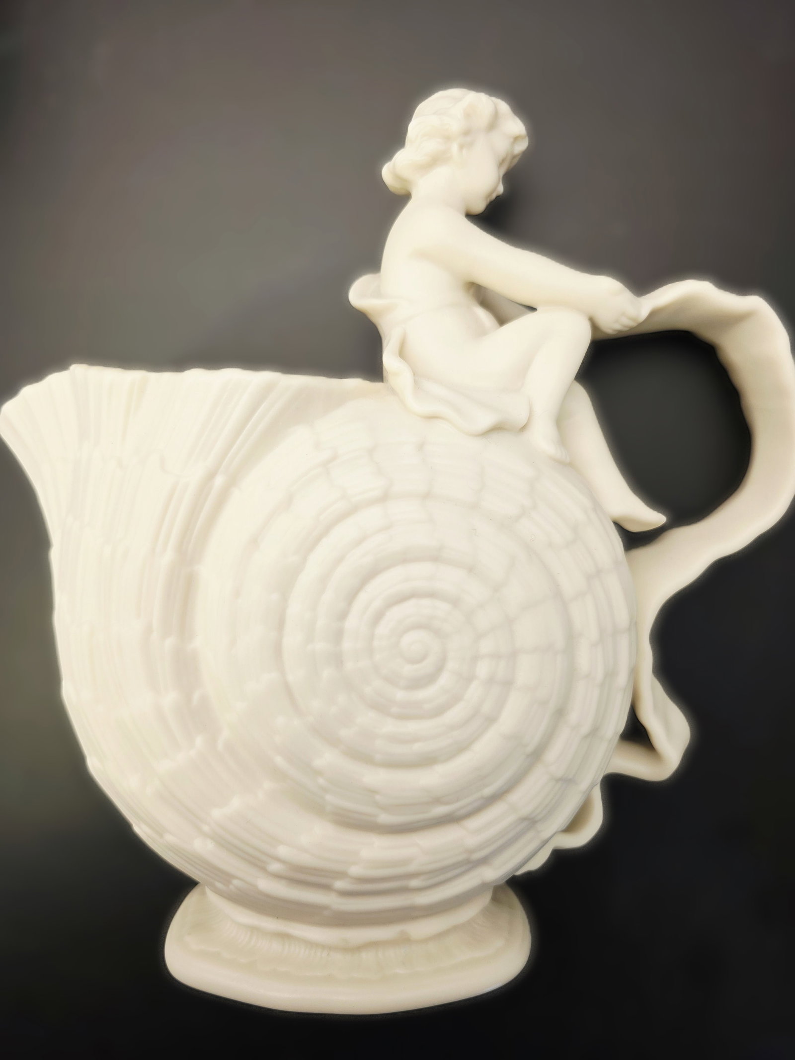 Walter Scott Lenox Nautilus vase: matte off white Lenox porcelain Walter Scott Lenox Nautilus vase featuring a seated cupid figure.This piece was originally designed by Walter Scott Lenox for the Willets Manufacturing Company in