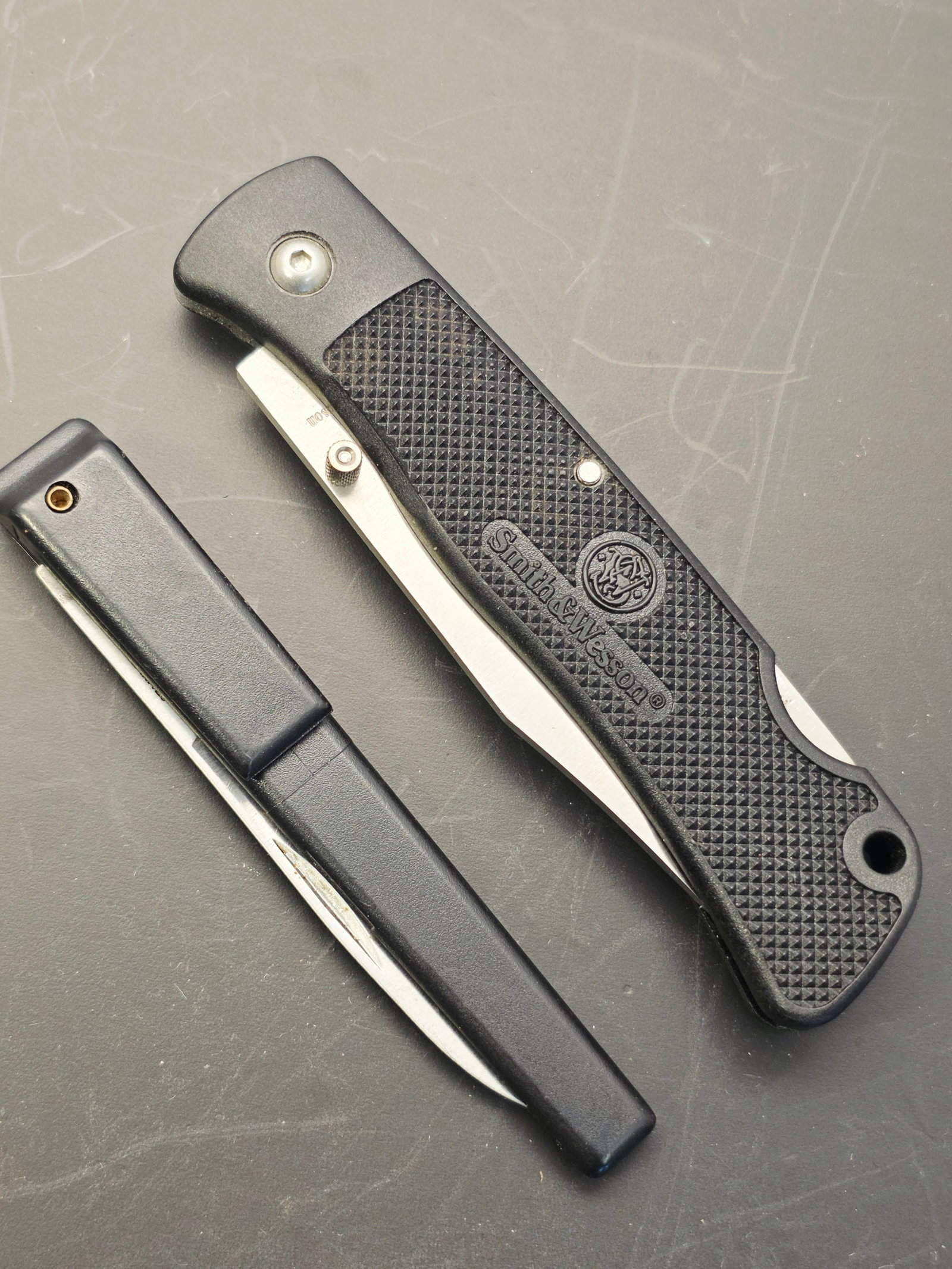2 vintage pocket knives, Smith & Wesson: This is a first edition first run vintage Smith & Wesson Model SW-540 folding pocket knife featuring a black textured handle, with a pen knife