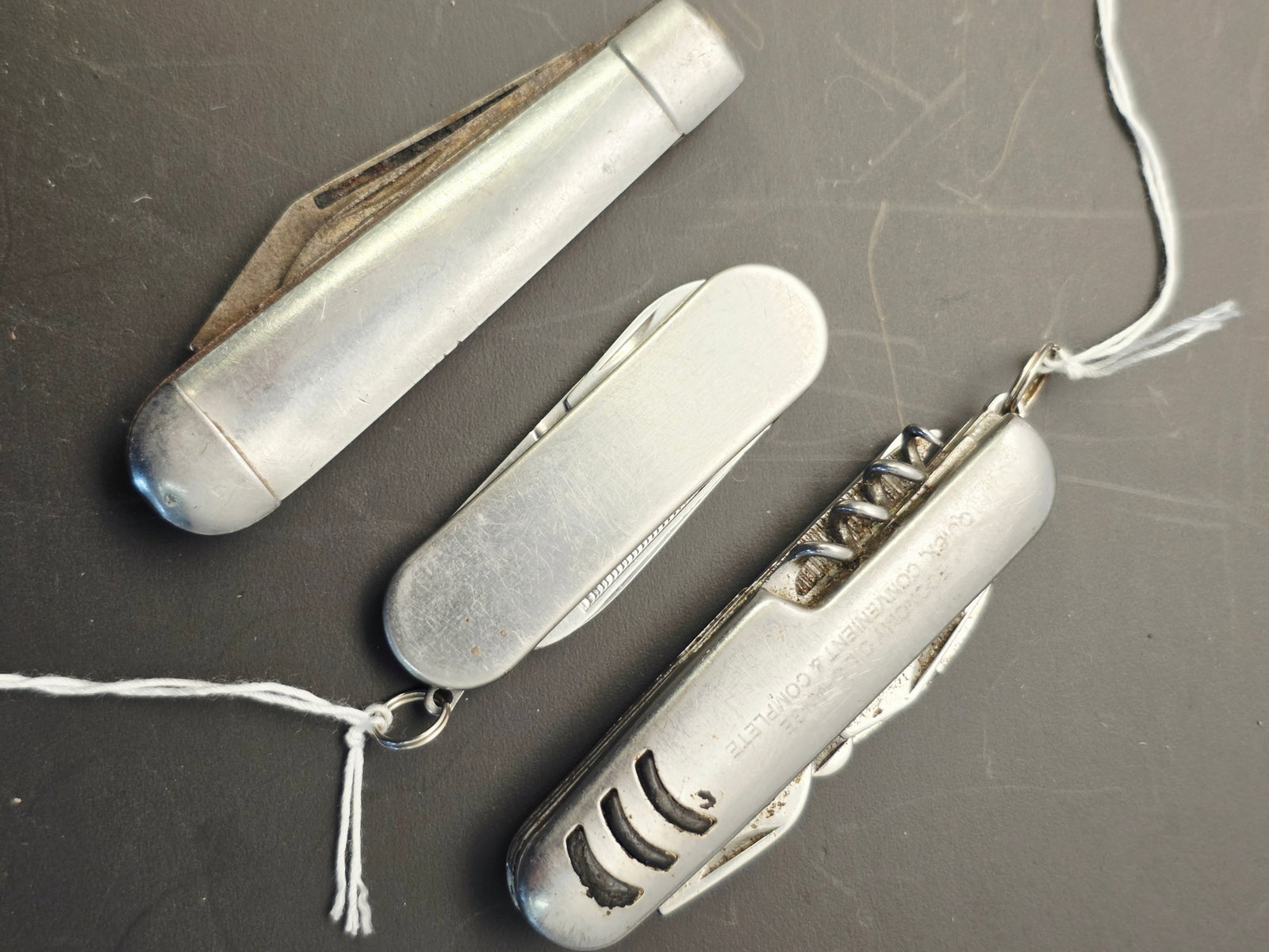 3 vintage pocket knives: These are silver-colored stainless steel multi-tool pocket knives, likely intended for promotional use or corporate gifting