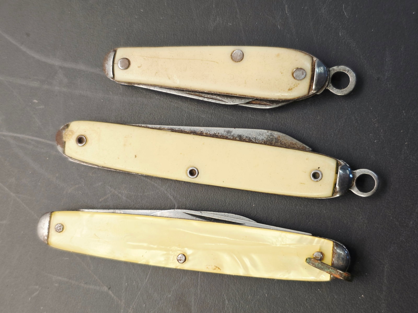 3 vintage Colonial pocket knives, key fob knives: vintage Colonial, Imperial, or Providence Cutlery Company pocket knives, often found with pearlescent "Nu-Pearl" plastic handles.Manufacturing Era: Many of these compact, keychain-style knives date