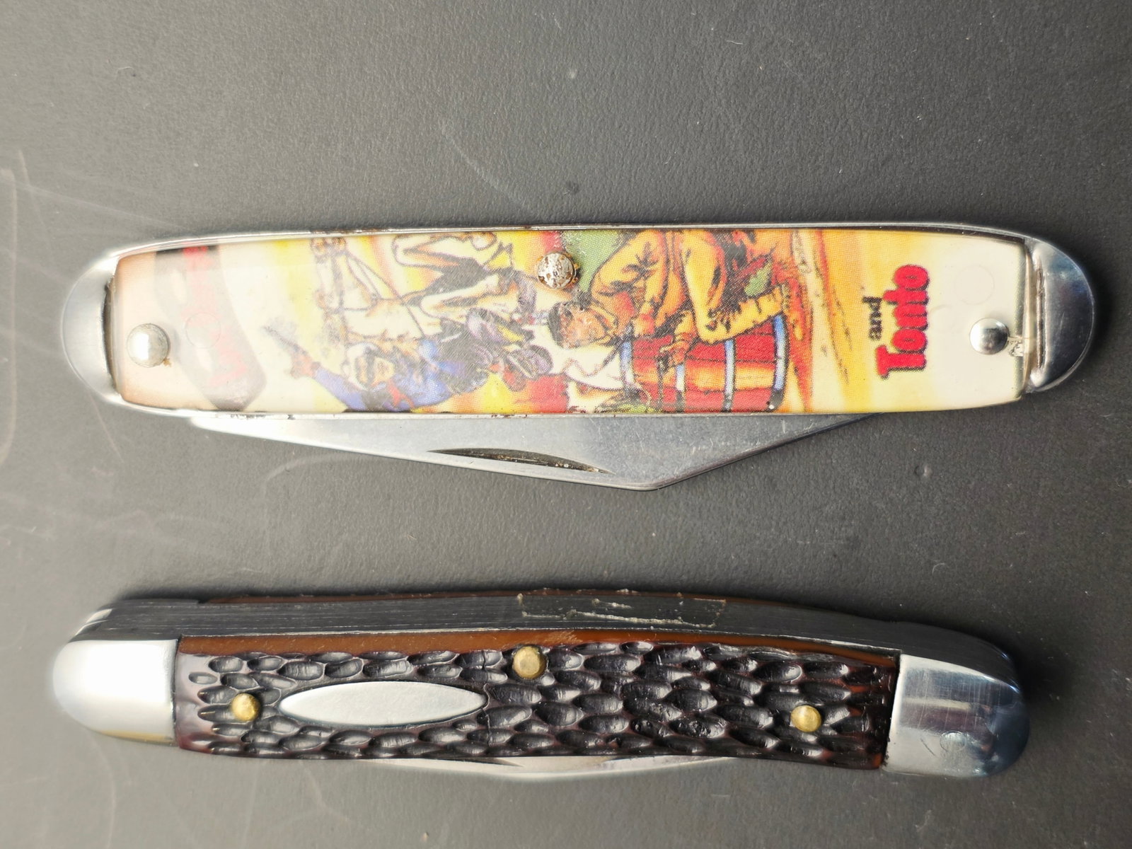 2 vintage folding pocket knives, one is a Lone Ranger Knife: These are vintage folding pocket knives, one featuring western heroes, produced by the Novelty Knife Company.Design Details: The knife pictured top features characters such as The Lone Ranger and
