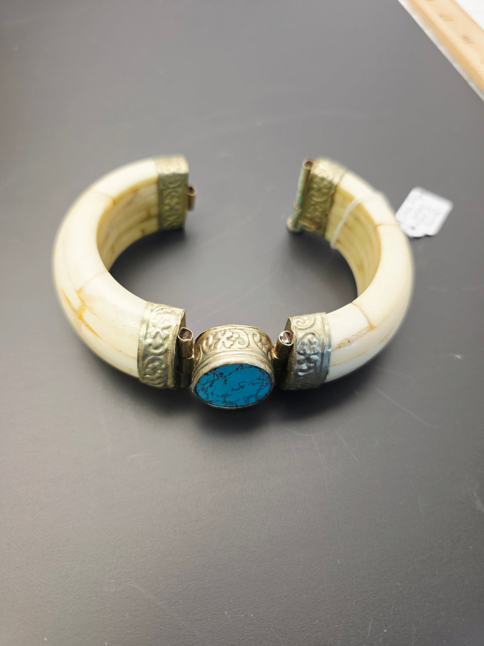 water buffalo bone vintage hinged bracelet: This is a vintage hinged bracelet crafted from water buffalo bone and accented with silver-tone metal and a blue turquoise gemstone.