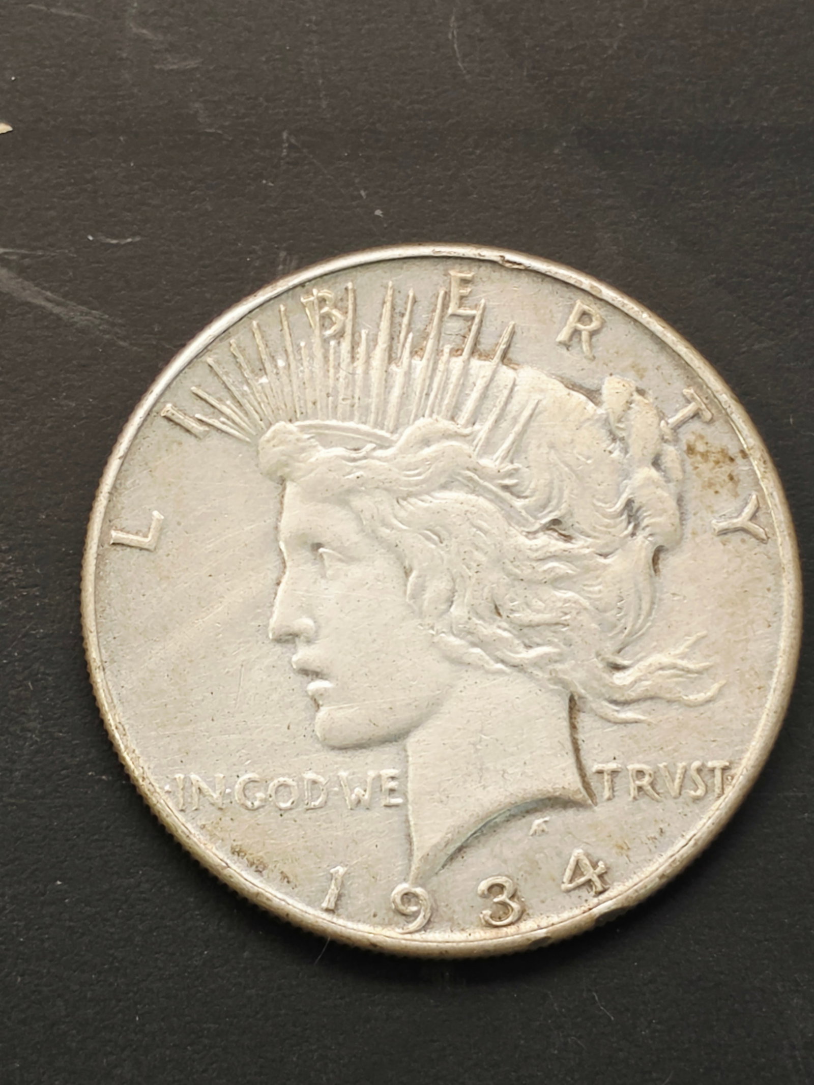 1934 U.S. Peace silver dollar coin: U.S. Peace silver dollar coin, which was minted from 1921 to 1935, and again starting in 2021.Design: Designed by Anthony de Francisci, the obverse shows a profile of the Goddess of Liberty, while the
