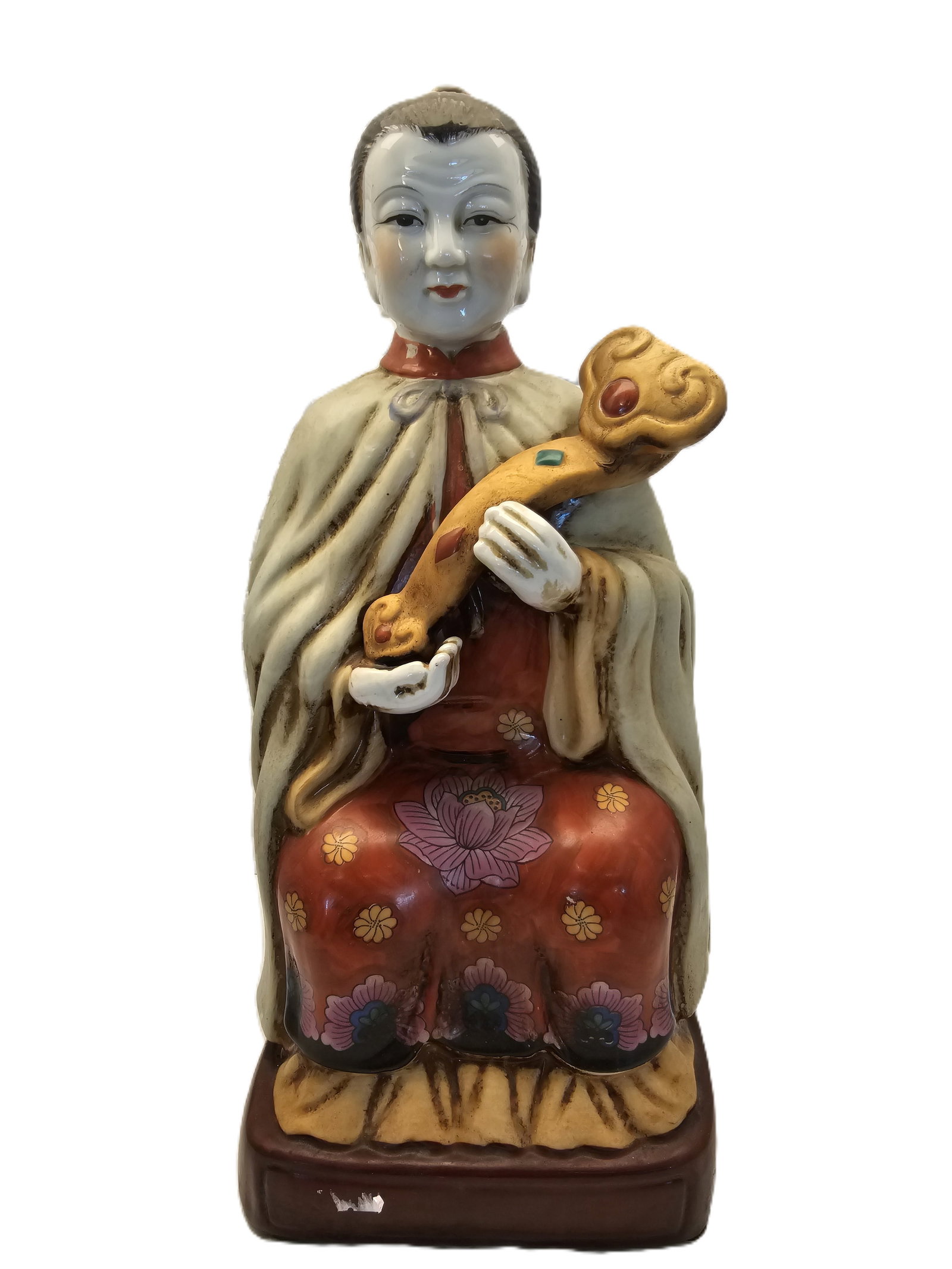 Vintage Or Antique Chinese Porcelain Statue Depicting A Seated Figure Holding A Ceremonial Object: Chinese porcelain statue depicting a seated figure holding a ceremonial object known as a ruyi scepter.Design Details: The figure is dressed in a long, cream-colored cape over a vibrant red robe