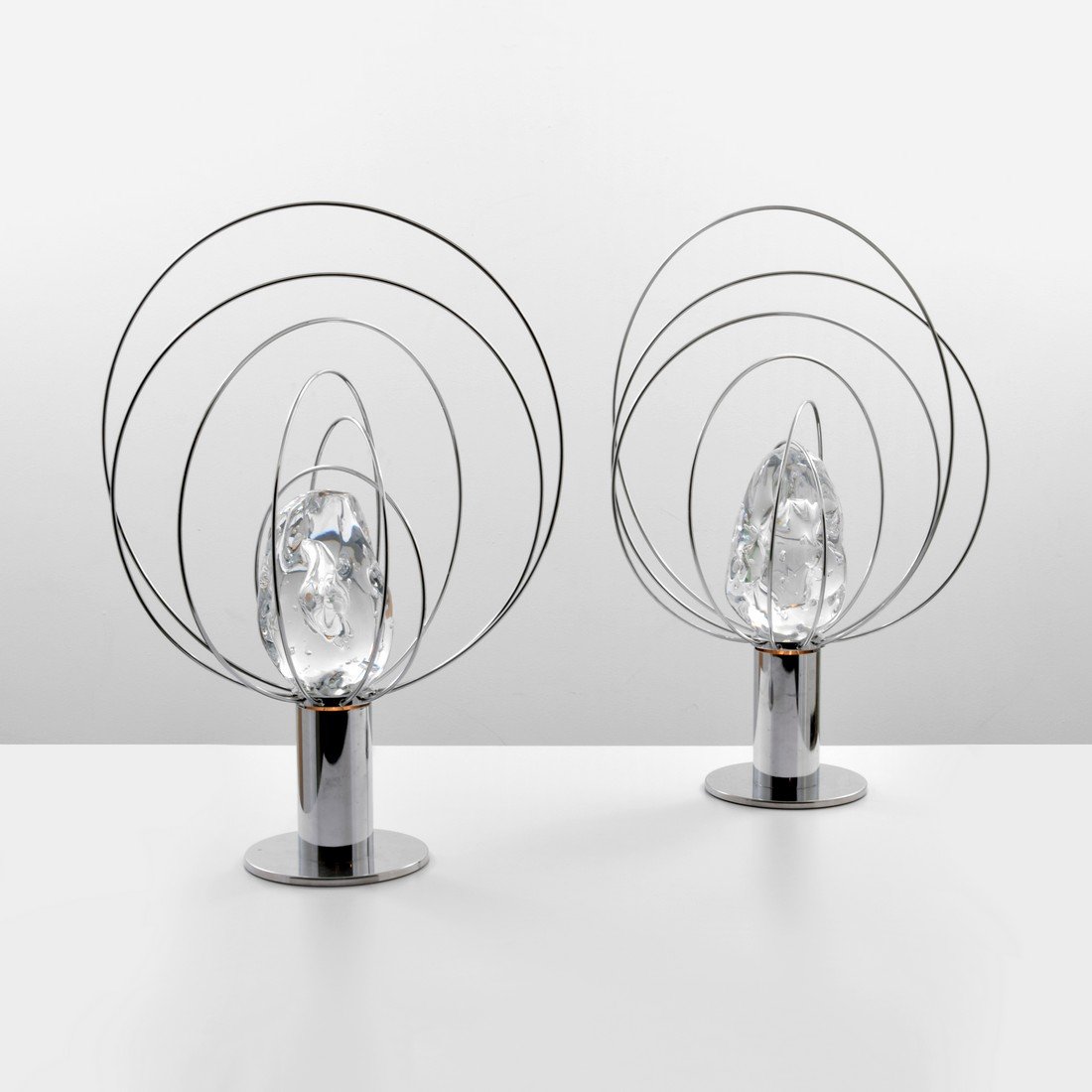 Pair of Angelo Brotto Lamps: Designer & Manufacturer: Angelo Brotto; Esperia Markings: Esperia label Country of Origin & Materials: Italy; glass, chromed metal Additional Information: Each lamp has one socket and a large glass el