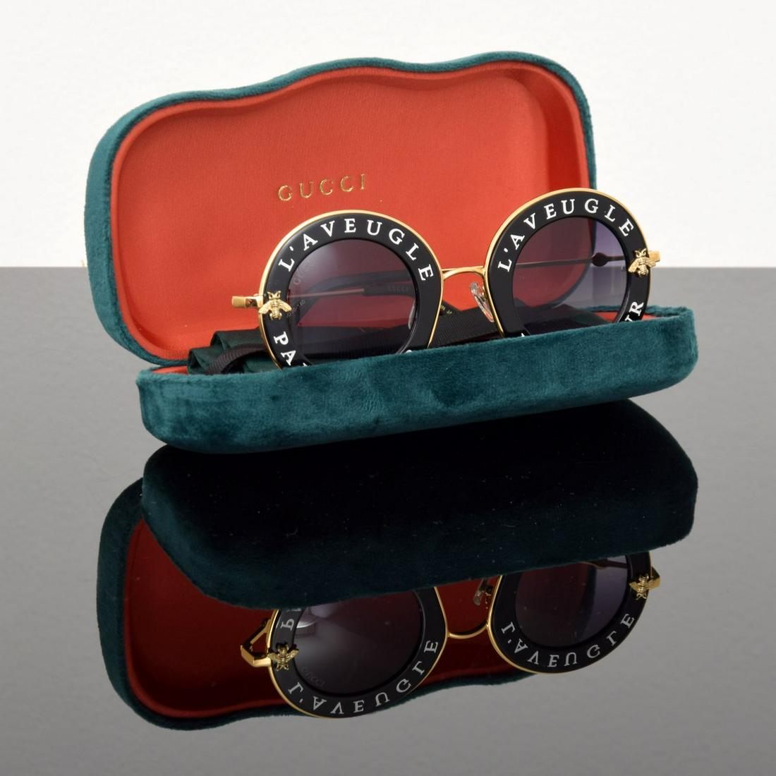 Gucci "L'Aveugle Par Amour" Sunglasses: Artist/Designer; Manufacturer: Gucci Marking(s); notes: Gucci imprints, GG113S 001 44[]30-140 Country of origin; materials: Japan; metal, plastic, cloth Dimensions (H, W, D): glasses (unfolded): 2.25"