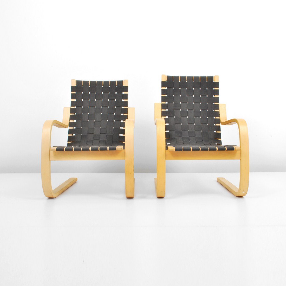 Pair of Alvar Aalto Lounge Chairs: Designer & Manufacturer: Alvar Aalto; Artek Markings: none Country of Origin & Materials: Finland; birch, nylon Additional Information & Circa: Pair of cantilevered arm chairs, model #406, by Alvar Aa