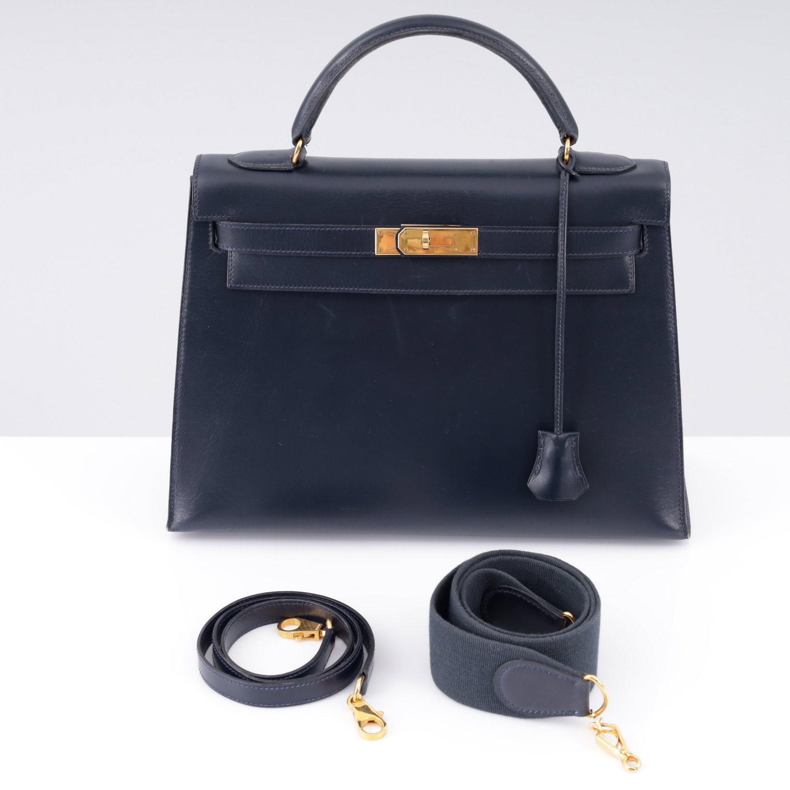 Hermes KELLY 32 Navy Box Leather Handbag: Artist/Designer/Manufacturer: Hermes (France) Marking(s); notes: Hermes imprints, blind stamp, (W), marking(s); 1993 Materials: box calf leather, gold-tone metal hardware