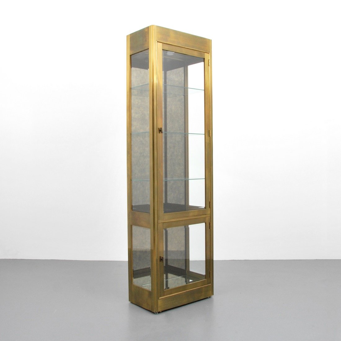 Mastercraft Cabinet/Vitrine: Designer & Manufacturer: Mastercraft Markings: none Country of Origin & Materials: USA; glass, brass Additional Information & Circa: Cabinet/vitrine with two doors revealing glass shelves by Mastercra