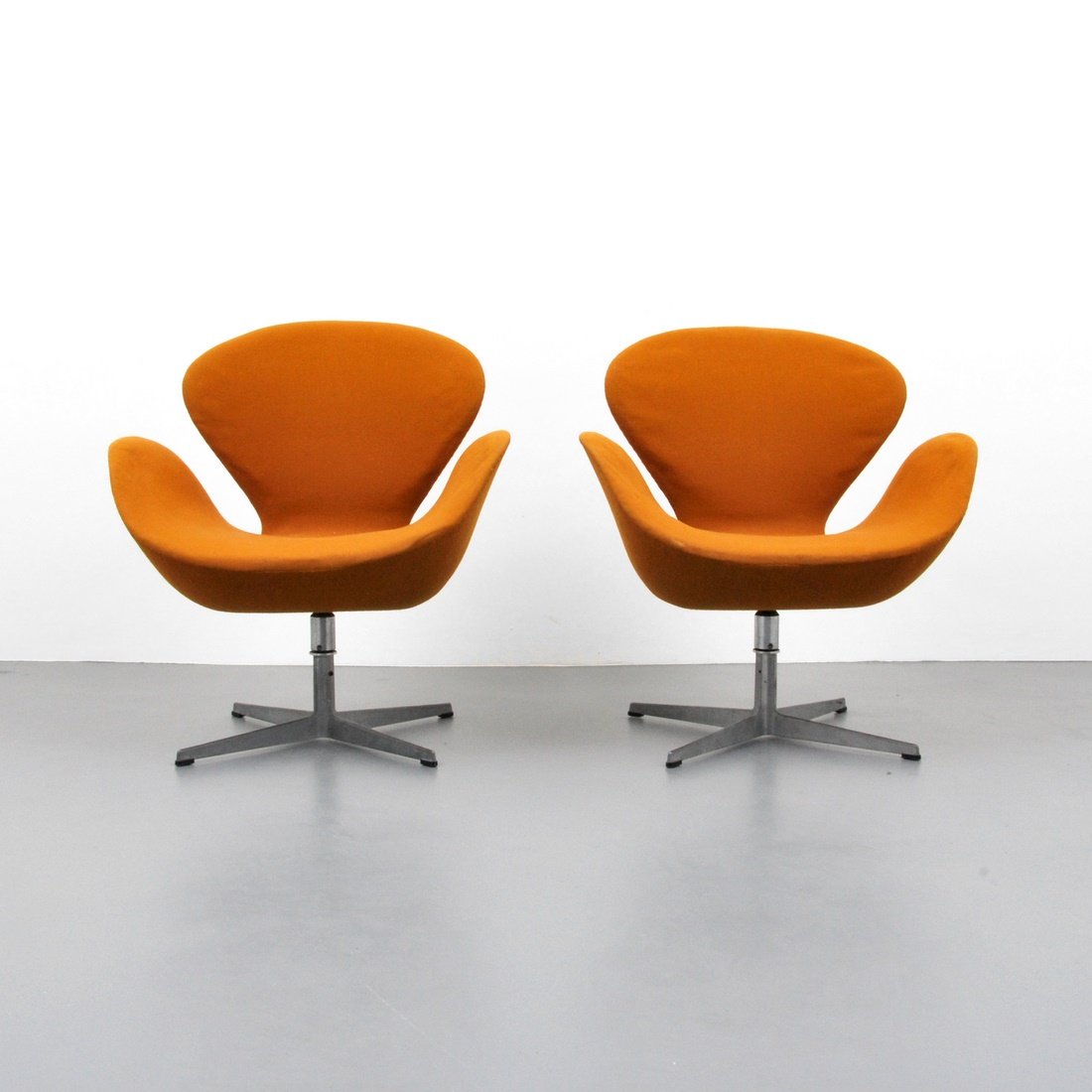 Arne Jacobsen 'Swan' Chairs, 1st Edition: Designer & Manufacturer: Arne Jacobsen; Fritz Hansen Markings: none Country of Origin & Materials: Denmark; cast aluminum, fabric Additional Information & Circa: Pair of first edition 'Swan' swivel lo