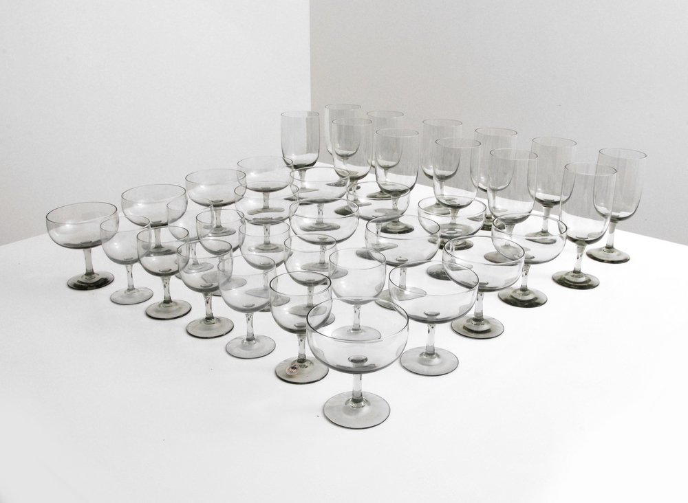 Per Lutken Set of Stemware, 36 Pieces: Designer (Artist) & Manufacturer: Per Lutken; Kastrup-Holmegaard Markings: marked Country of Origin & Materials: Denmark; glass Additional Information: Set of hand-blown “Elsinore” smoked transpar