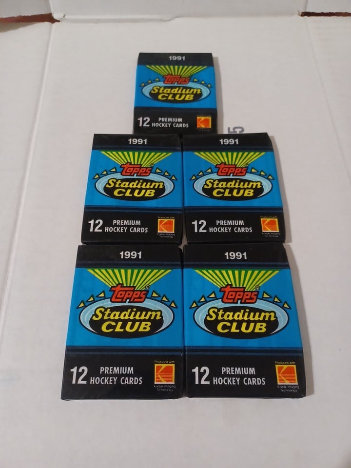 1991 Topps Stadium Club Hockey 5 Sealed Packs – Vintage Unopened 12 Cards Each: The product is a set of 1991 Topps Stadium Club Premium Hockey Cards, consisting of 5 unopened packs containing a total of 60 cards. The cards are standard size, featuring players from the National Ho