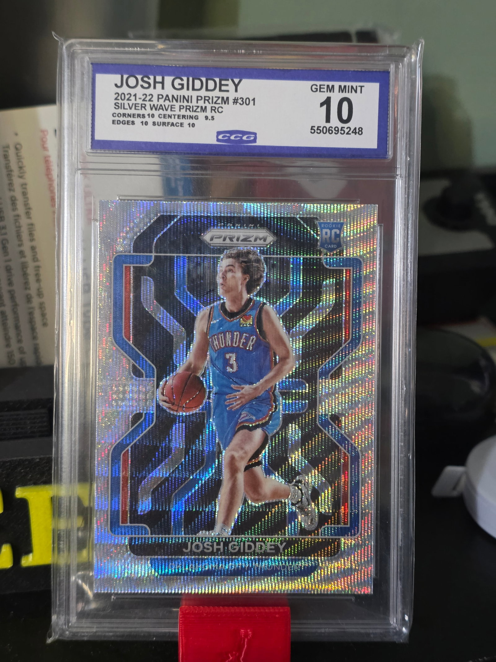 2021 Josh Giddey Panini Prizm Rookie Premium Set Silver Wave GEM MT CCG 10 #301: The 2021-22 Panini Prizm Josh Giddey Silver Wave Prizm Rookie #301 CCG 10 is a highly sought-after sports trading card featuring the promising NBA rookie Josh Giddey. This original card from Panini's