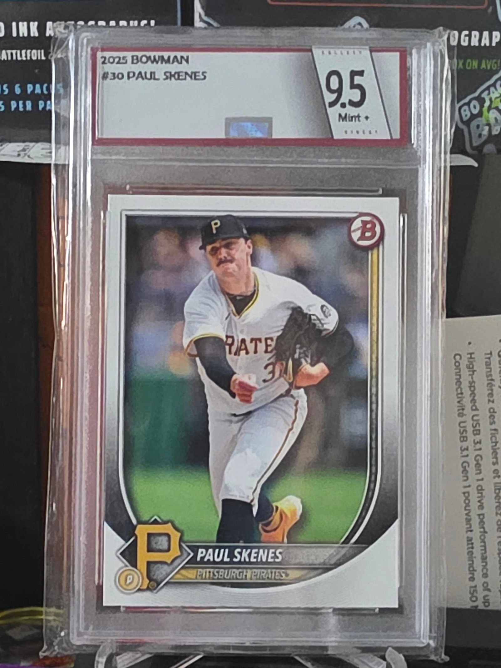 2025 Bowman Base Set Paul Skenes #30 Pittsburgh Pirates Collect Direct 9.5: The product is a 2025 Bowman #30 trading card featuring baseball player Paul Skenes from the Pittsburgh Pirates. This original card is graded 9.5 and is a standard size for sports trading cards. It is