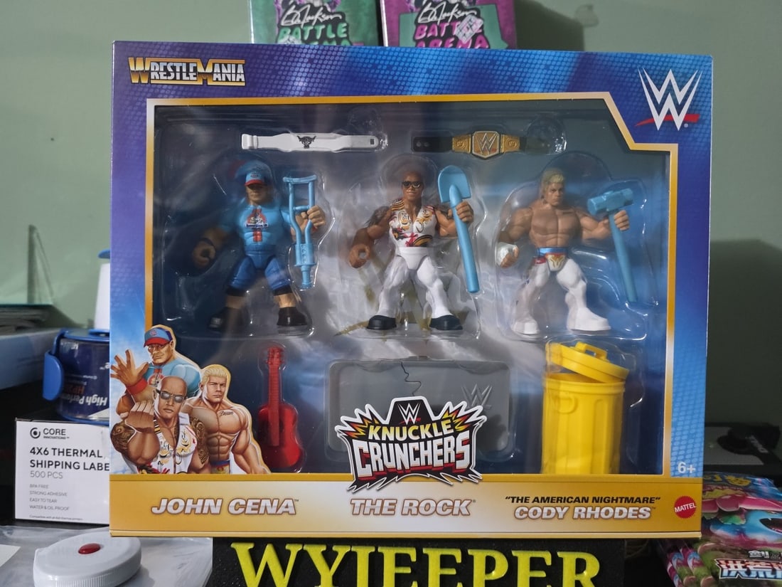 WWE Knuckle Crunchers John Cena, The Rock & Cody Rhodes Action Figure Set: The WWE Knuckle Crunchers John Cena, The Rock & Cody Rhodes Action Figure Set features three iconic WWE wrestlers in colorful plastic dolls. The figures are in a 1:18 scale and come in a boxed set, ma