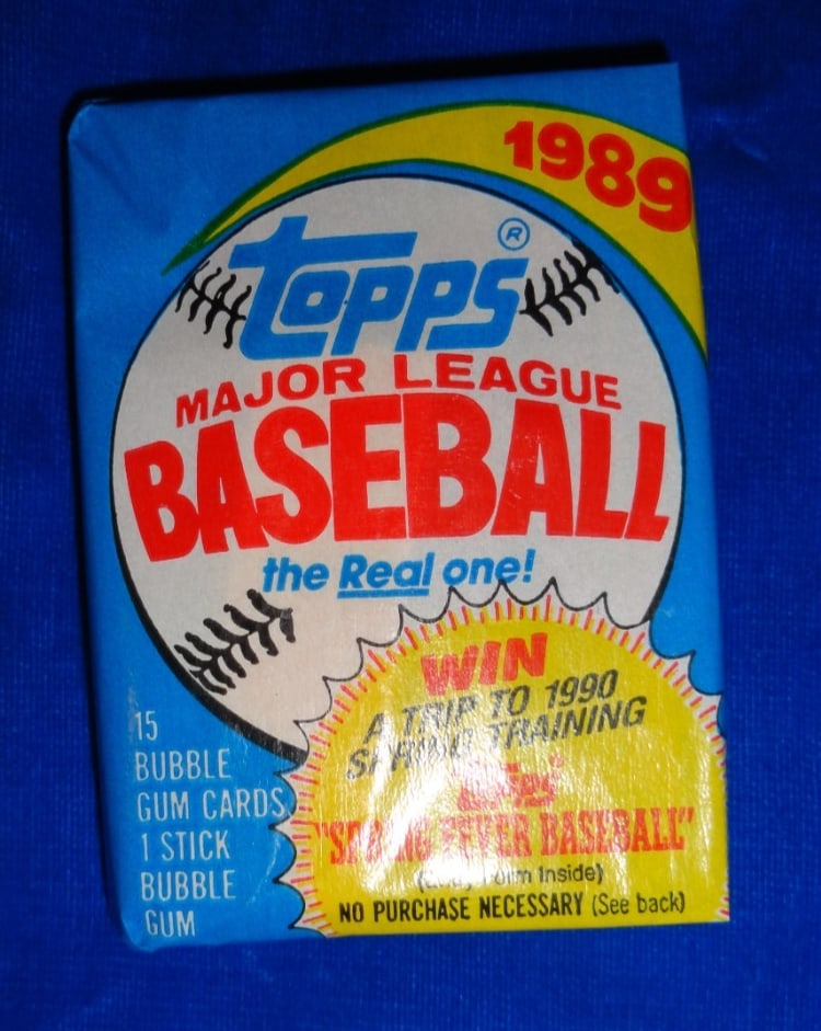 1989 Topps Baseball Wax Pack Gum Intact: The 1989 Topps Baseball Cards come in an unopened sealed wax pack containing 15 cards featuring iconic players such as Don Mattingly, Kirby Puckett, Cal Ripken Jr., and more. This vintage set, manufac
