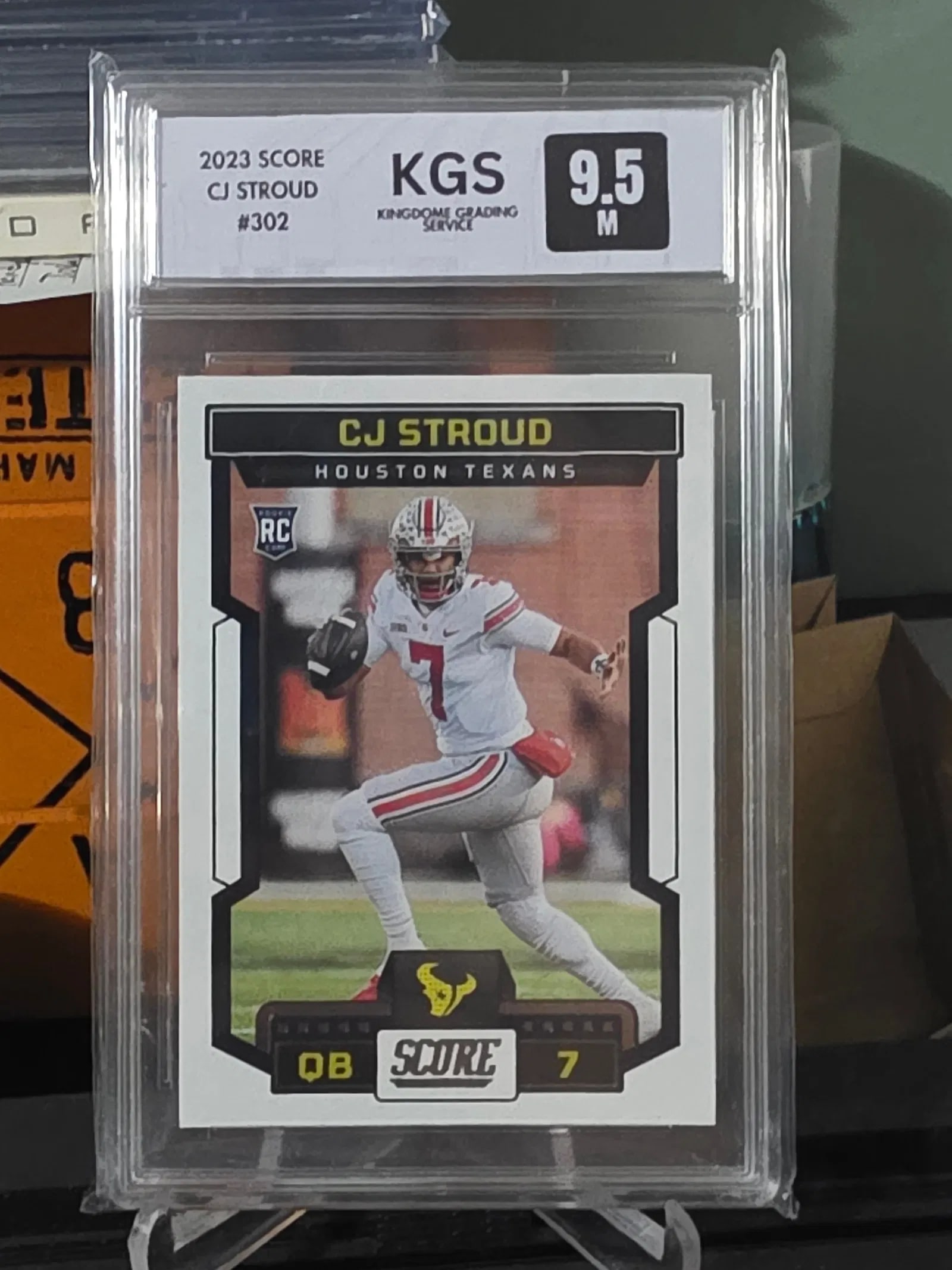 2023 Panini SCORE C.J. STROUD #302 Rookie RC Football Card: This 2023 Panini SCORE C.J. STROUD #302 Rookie RC Football Card has been professionally graded with a KGS 9.5 M. It features the Houston Texans player C.J. Stroud and is an original, authentic trading