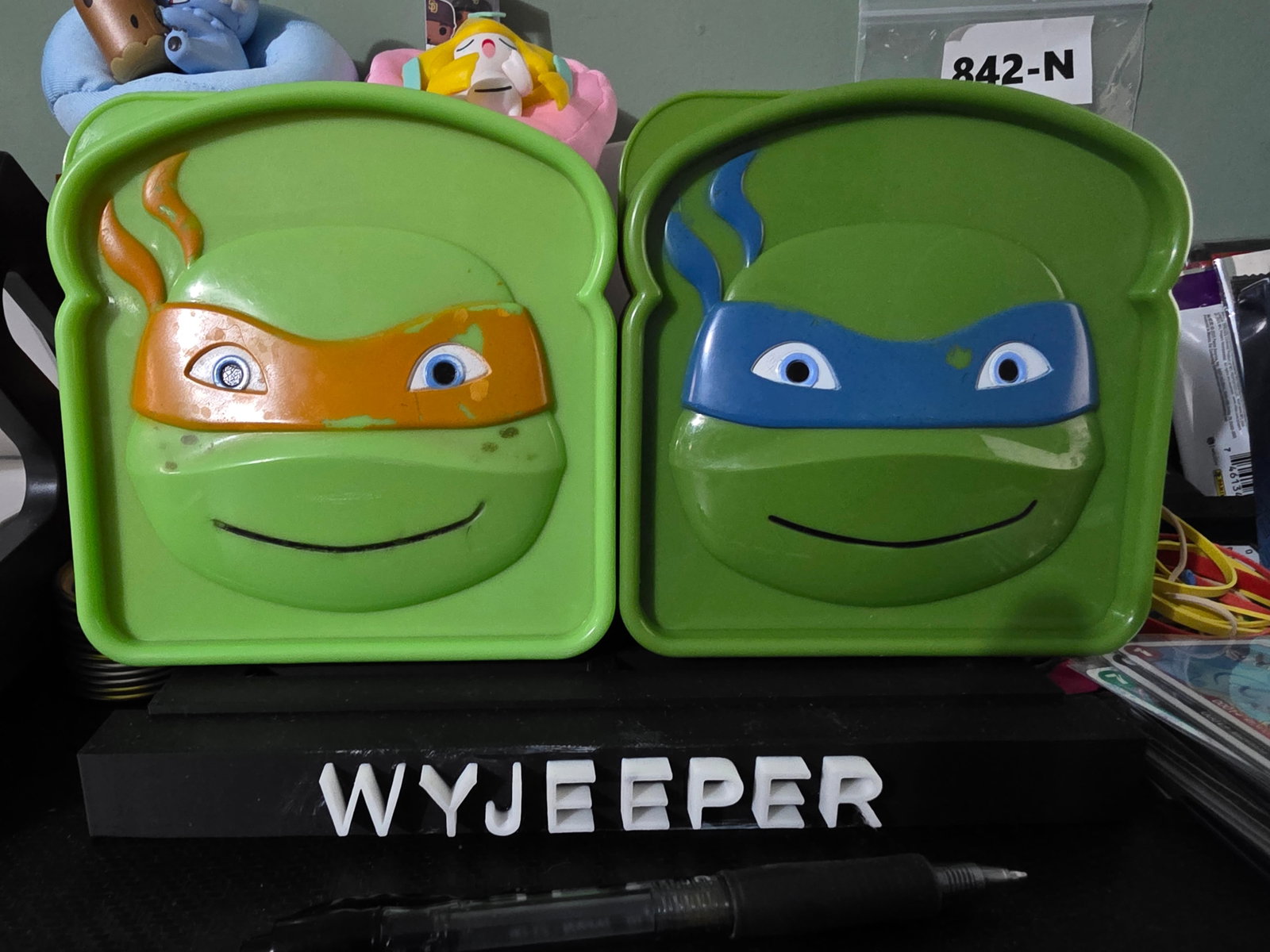 2 TMNT sandwich containers by EVRI: The TMNT sandwich containers by EVRI are a set of two green plastic sandwich boxes featuring a snap lid design. With a length of 5 inches and a width of 4.75 inches, these containers are perfect for