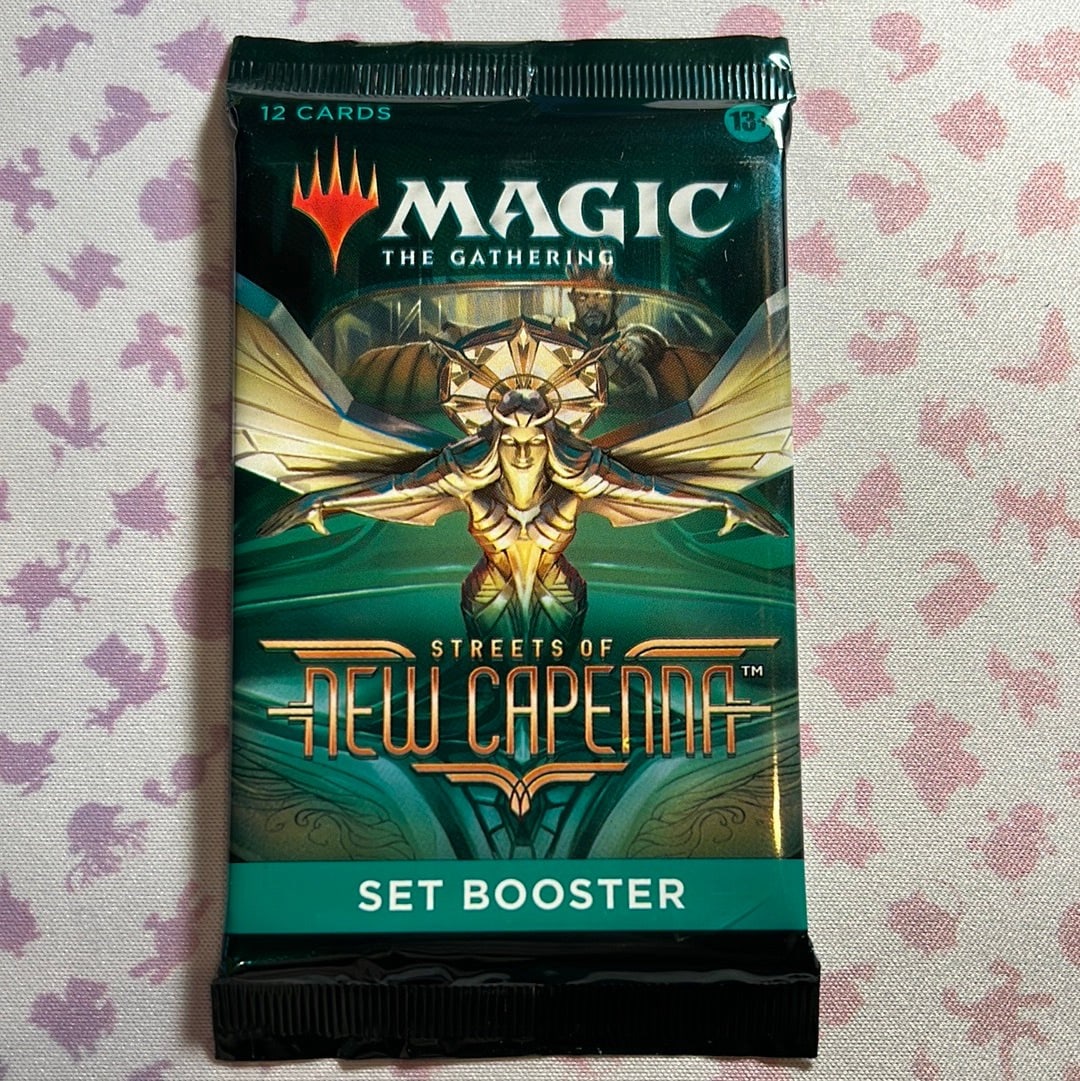 Magic: The Gathering - Streets of New Capenna Set Booster Pack: The product is a booster pack from the Magic: The Gathering 2022 Streets of New Capenna set, containing a total of 12 cards. Manufactured by Wizards of the Coast in the United States, this pack is des