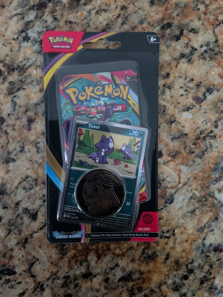 Pokemon TCG Mega Evolution—Chaos Rising Booster Pack + Toxel Promo & Coin: The product is a Pokemon TCG Mega Evolution—Chaos Rising Booster Pack featuring Toxel character with a promo card and coin included. The pack contains 10 standard-sized cards made of card stock 