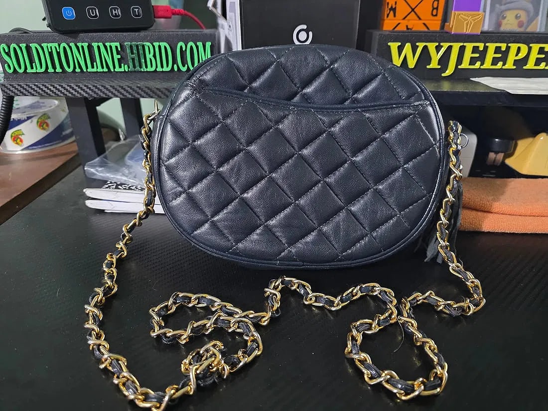 Quilted crossbody, blue exterior,gold chain strap,and a tassel zipper pull: The quilted crossbody bag in black with a gold chain strap and tassel zipper pull is a stylish and geometrically sleek accessory for women. Made from faux leather, this small rectangular bag features