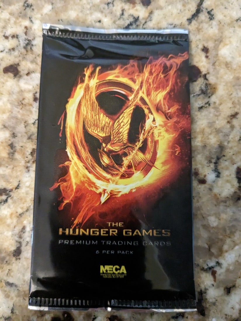 2012 NECA THE HUNGER GAMES TRADING CARD PACK(S) 1 PACK: Immerse yourself in the world of The Hunger Games with this premium trading card set from NECA. Featuring characters like Katniss Everdeen and Jennifer Lawrence, this pack includes 6 cards made from