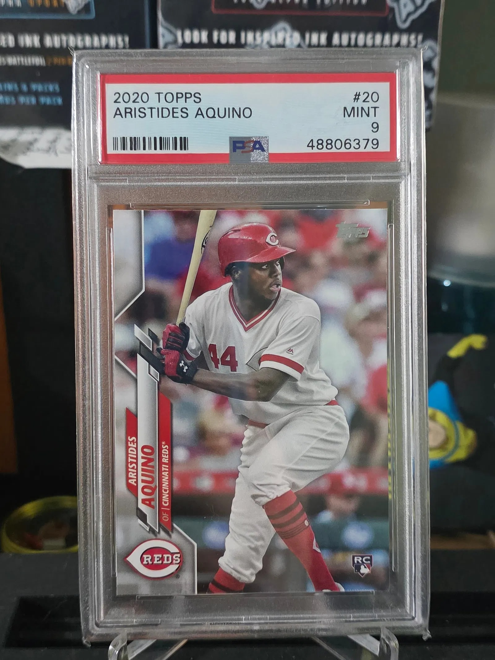2020 Topps. Aristides Aquino Rookie Card. RC. #20 PSA 9 MINT. Reds: The product is a 2020 Topps Aristides Aquino #20 Batting (RC) sports trading card graded as a PSA 9. It is a rookie card featuring the player Aristides Aquino from the Cincinnati Reds in Major League