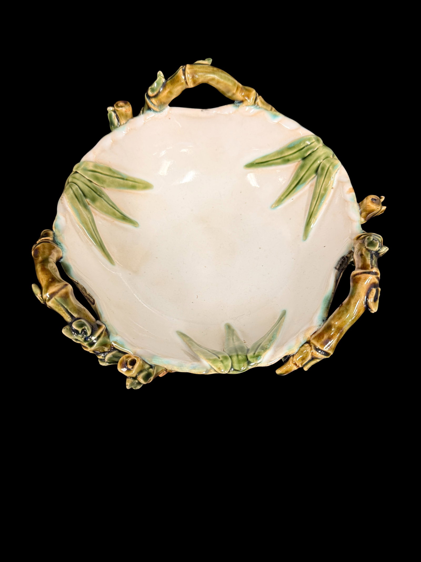 Ceramic Bowl with Bamboo and Floral Motif: A ceramic bowl with painted bamboo and floral motif in white and green with decorative handles. Asian-inspired ceramic bowls with nature motifs are perennial decorative collectibles.