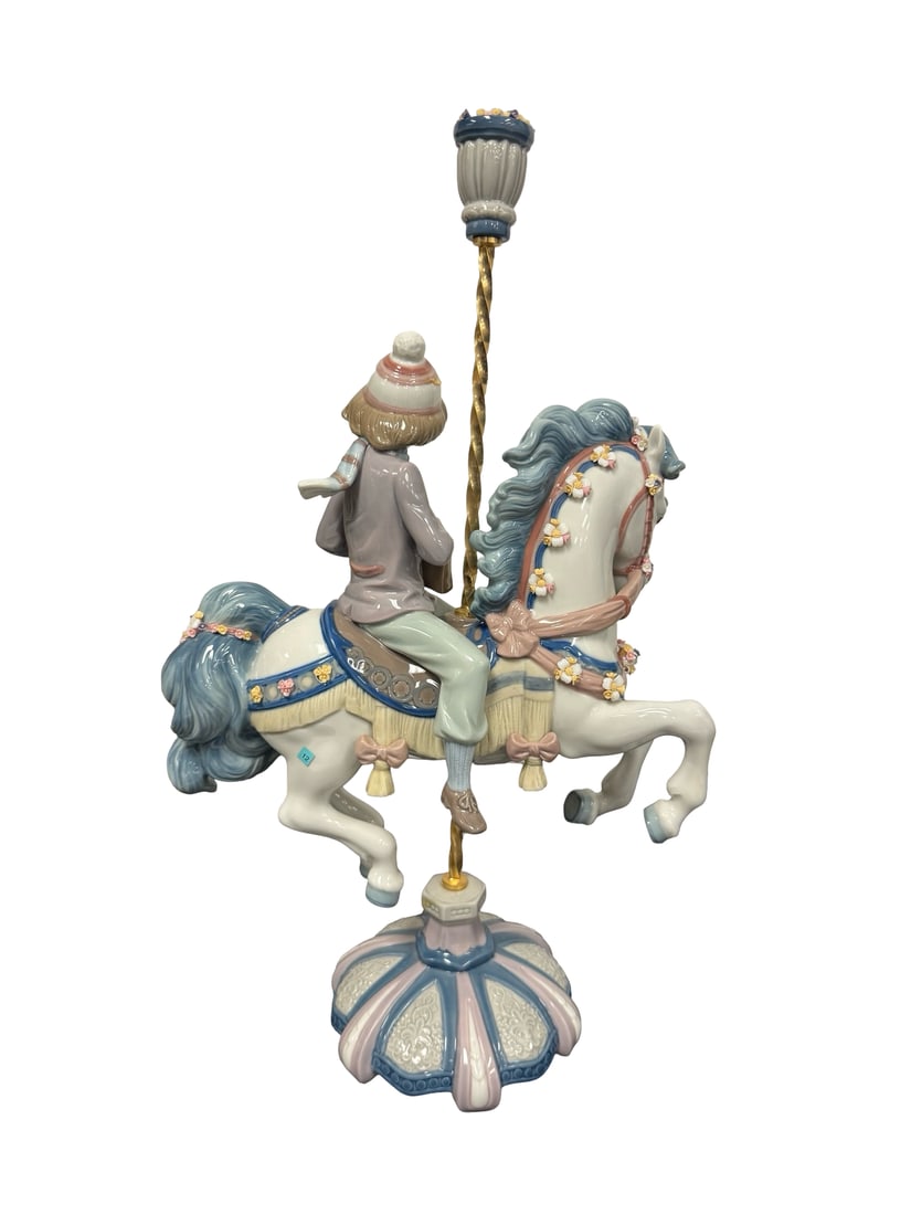 Lladro-Ride in the Park Figurine: Large Lladro- porcelain figurine featuring a young boy riding a carousel horse, titled "Ride in the Park" (model 01005370). The piece showcases a glossy finish with a muted pastel palette of blue, pin