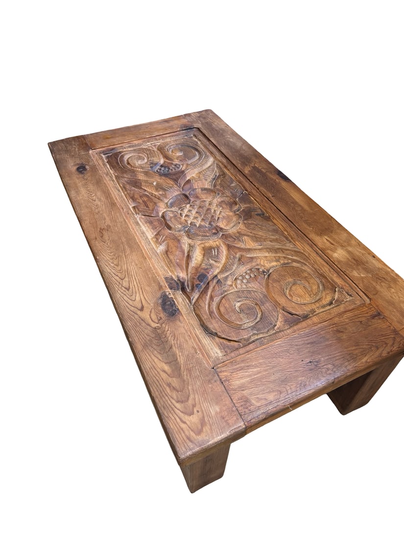 Rustic Hand-Carved Floral Wood Table: This rustic low-profile coffee table features a prominently hand-carved floral and scrollwork medallion on the tabletop. Constructed from solid wood with a dark stained finish, the piece showcases