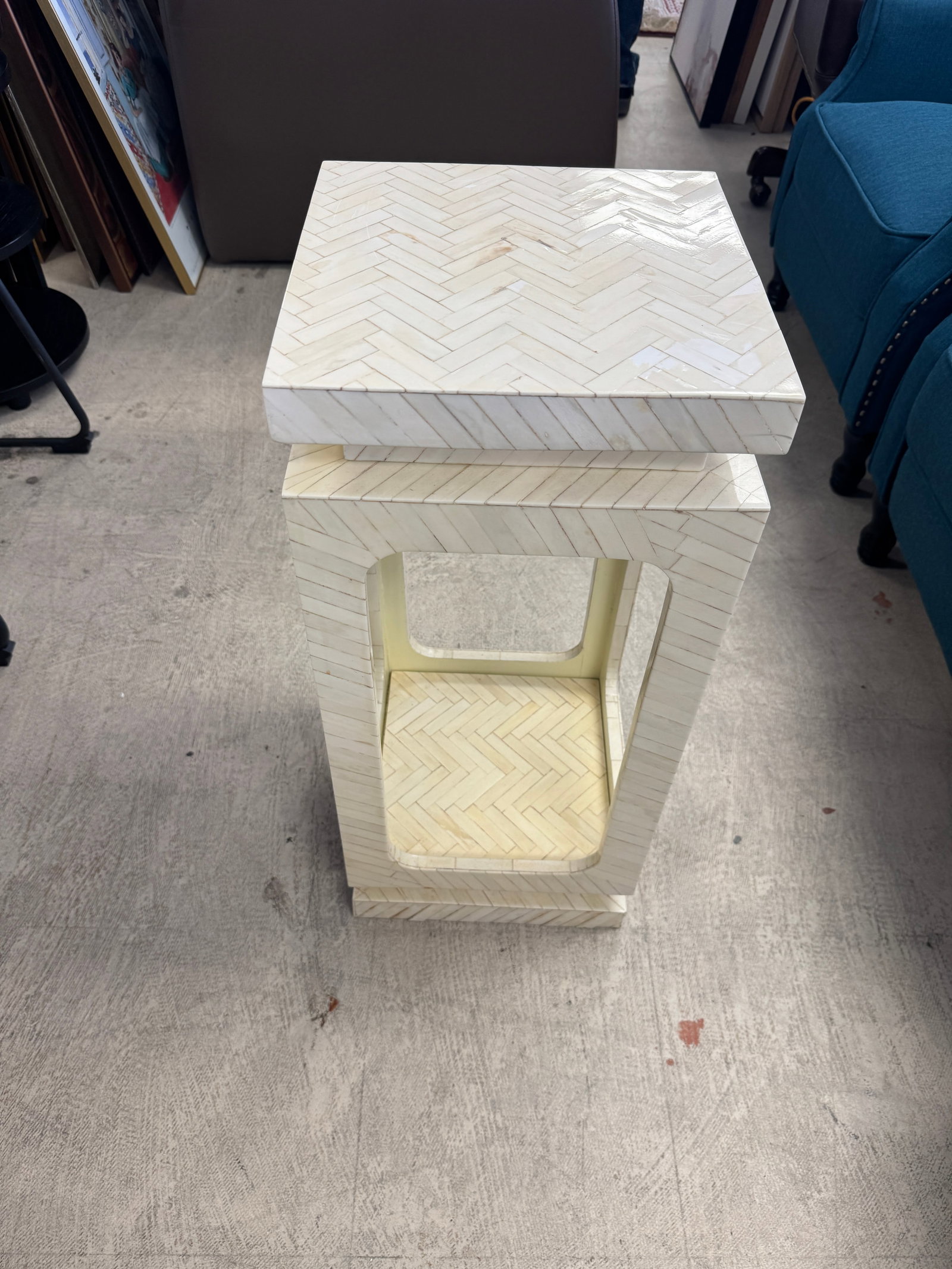 Hollywood Regency Style Bone Inlay Accen: This Hollywood Regency style accent table features a striking geometric design with cream-colored bone or resin inlay applied in a chevron pattern. The sculptural form includes an open rectangular
