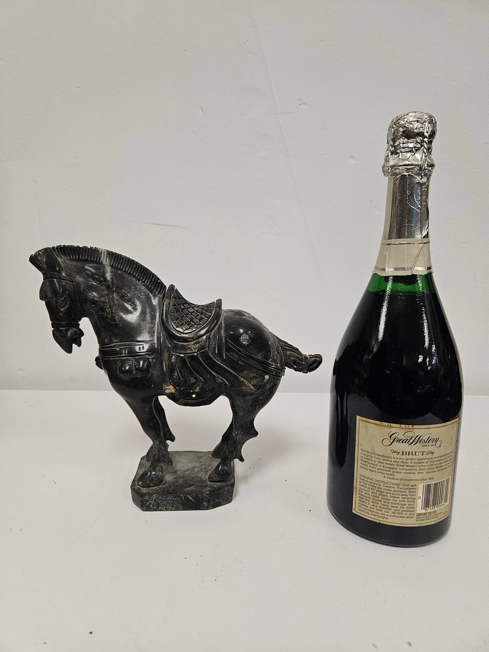 Carved Tang-Style Dark Stone Horse: This carved dark stone horse statue is designed in the Tang Dynasty style, featuring a saddled horse in a classic stout posture. The figure is masterfully carved from a dark green or black