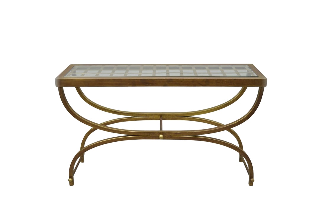 Hollywood Regency Glass & Brass Ta: This elegant coffee table features a rectangular glass top inset over a distinctive brass-finish grid pattern. The piece is supported by a graceful curule-style base with intersecting arched legs and