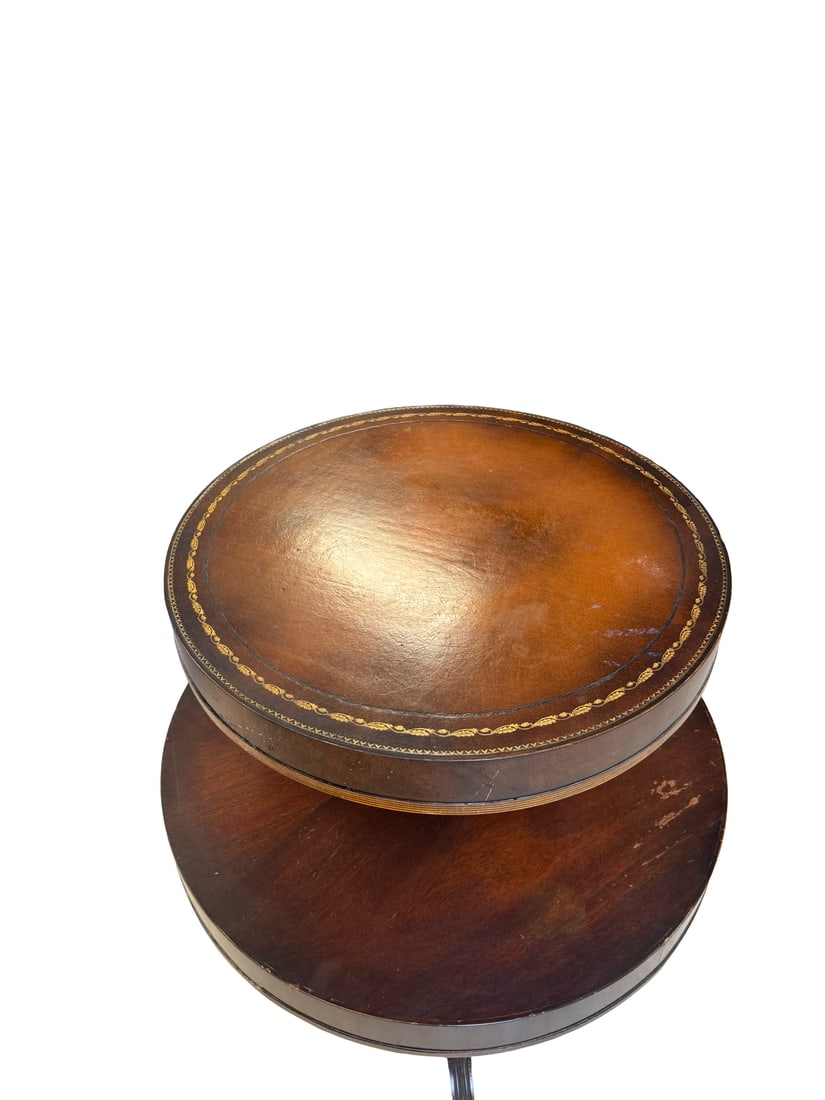 Regency Style Leather Top Mahogany Drum: This Regency style mahogany drum-top side table features a two-tier design supported by a fluted central pedestal and splayed tripod legs. The circular top is inset with a brown leather surface