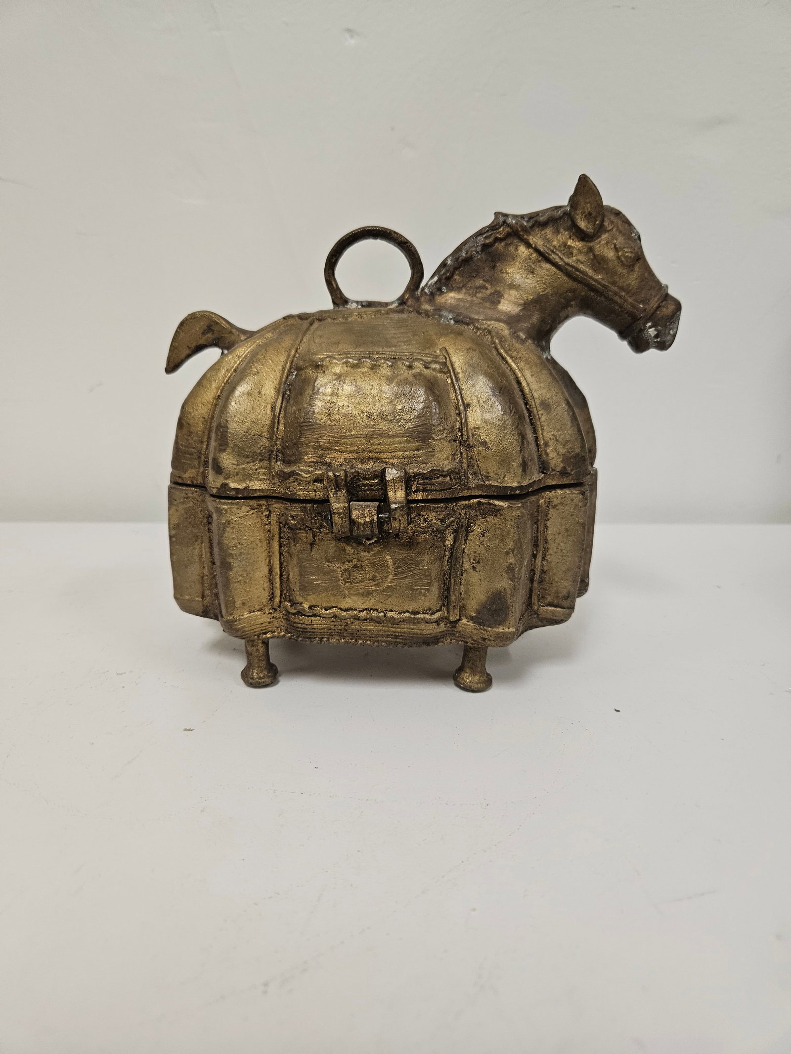 Cast Metal Horse-Form Hinged Trinket Box: This unique cast metal trinket box is designed in the form of a stylized horse or donkey with a rounded body. It features a hinged lid with a loop latch and is finished in a weathered gold-tone patina