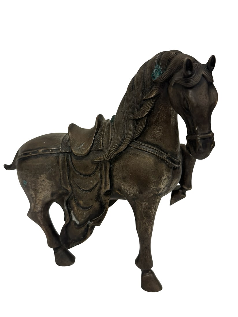 Bronze Tang Style Caparisoned Horse: This bronze table sculpture depicts a harnessed Tang style horse in a dynamic, high-stepping trotting pose. The figure features detailed ornamental tack including a saddle, breastplate, and flowing de