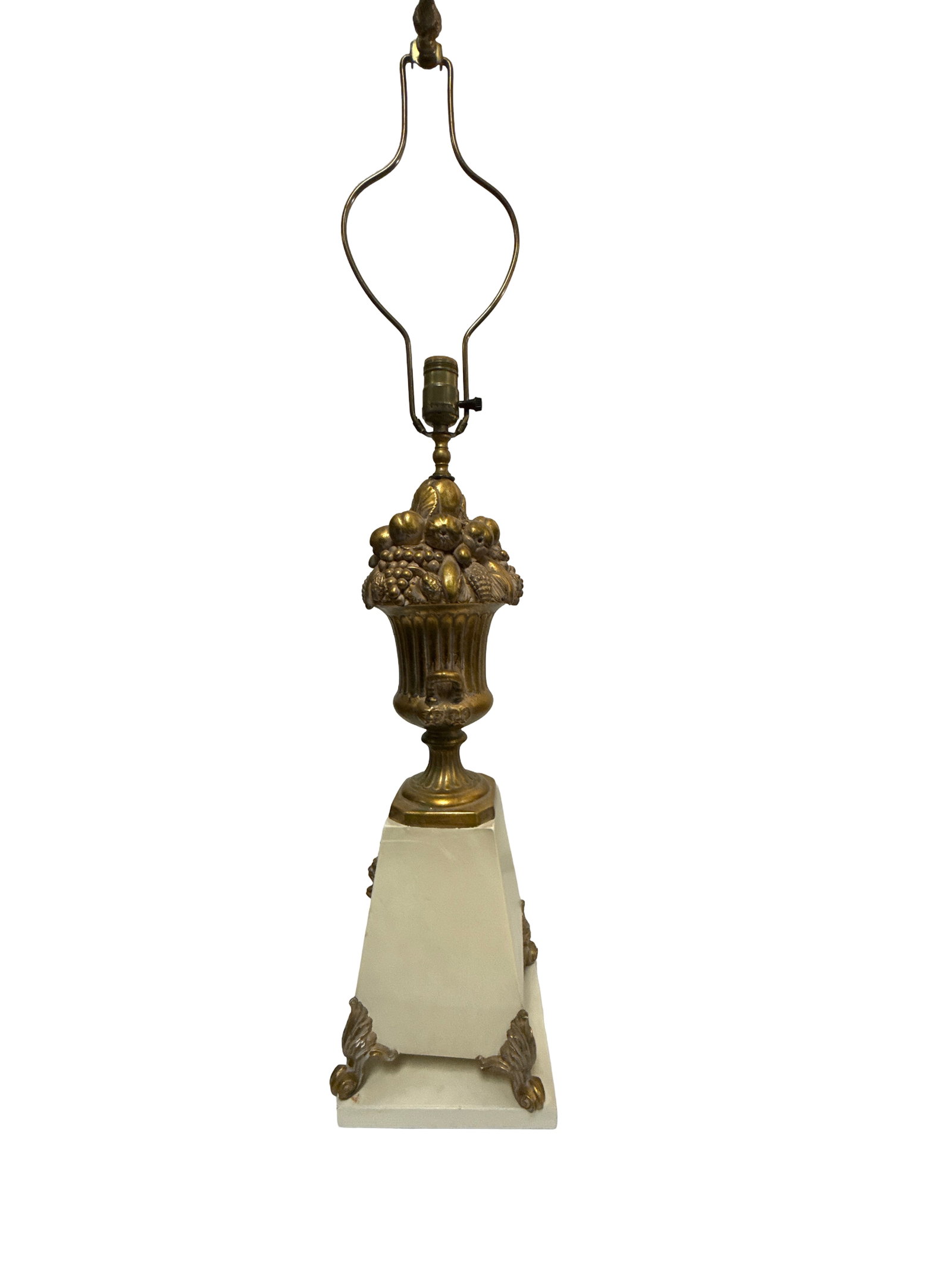 Neoclassical Style Fruit Urn Table Lamp: This vintage table lamp features a Neoclassical style with a decorative fruit-filled urn centerpiece in a burnished gold-tone finish. The urn sits atop a tapered cream-colored pedestal base, which is 