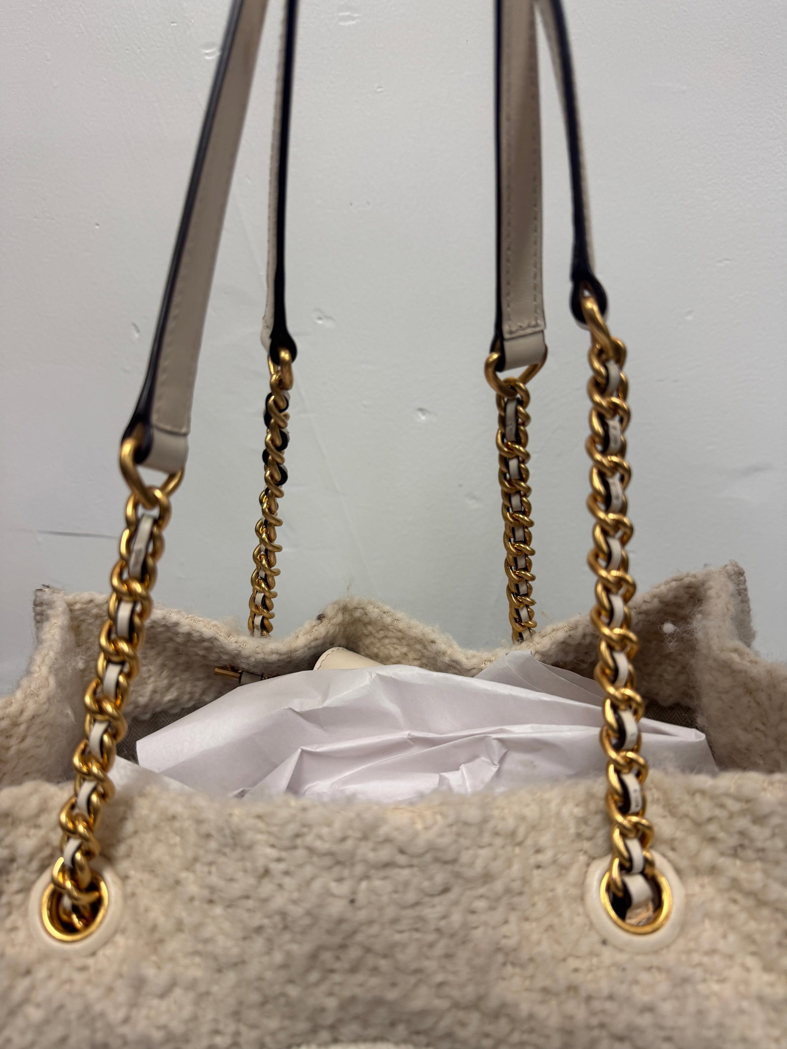 Tory Burch Ella Mini Tote: This cream-colored sherpa fleece tote features a prominent embroidered logo on the front face in a matching tone. It includes gold-tone chain straps interlaced with leather-style material and grommet 
