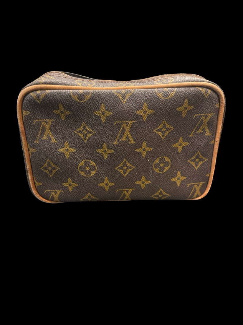 LV Style Monogram Travel Cosmetic Case: This travel cosmetic case features a classic LV-style monogram pattern on coated canvas with tan leather piping. The wrap-around zipper opens to a multi-compartment interior with several zippered pock